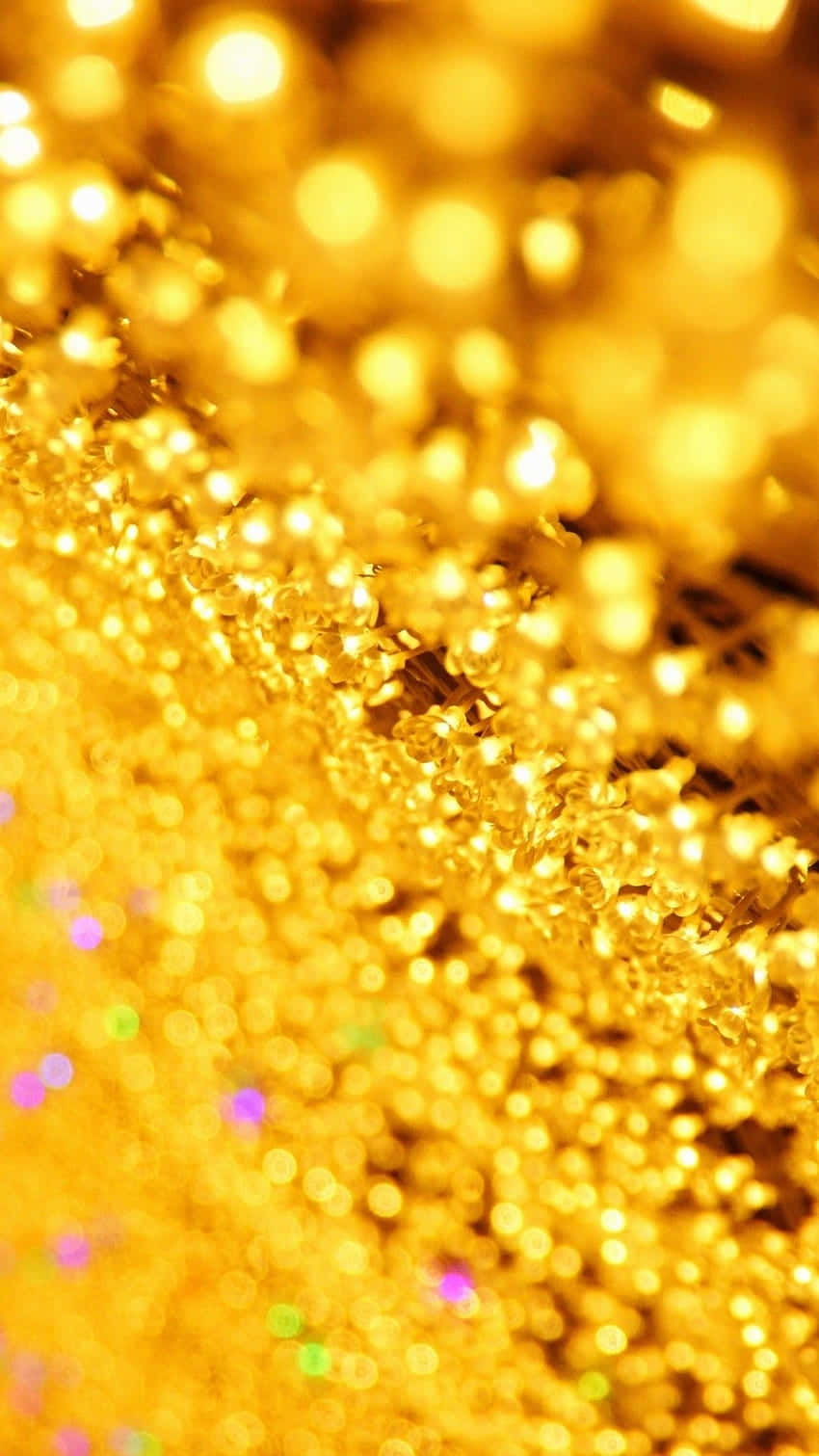 Yellow Glitter 桌布 壁紙 — 閃爍金色亮粉的特寫，帶有柔和散景和散落的彩虹閃光，營造出奢華光芒的質感。