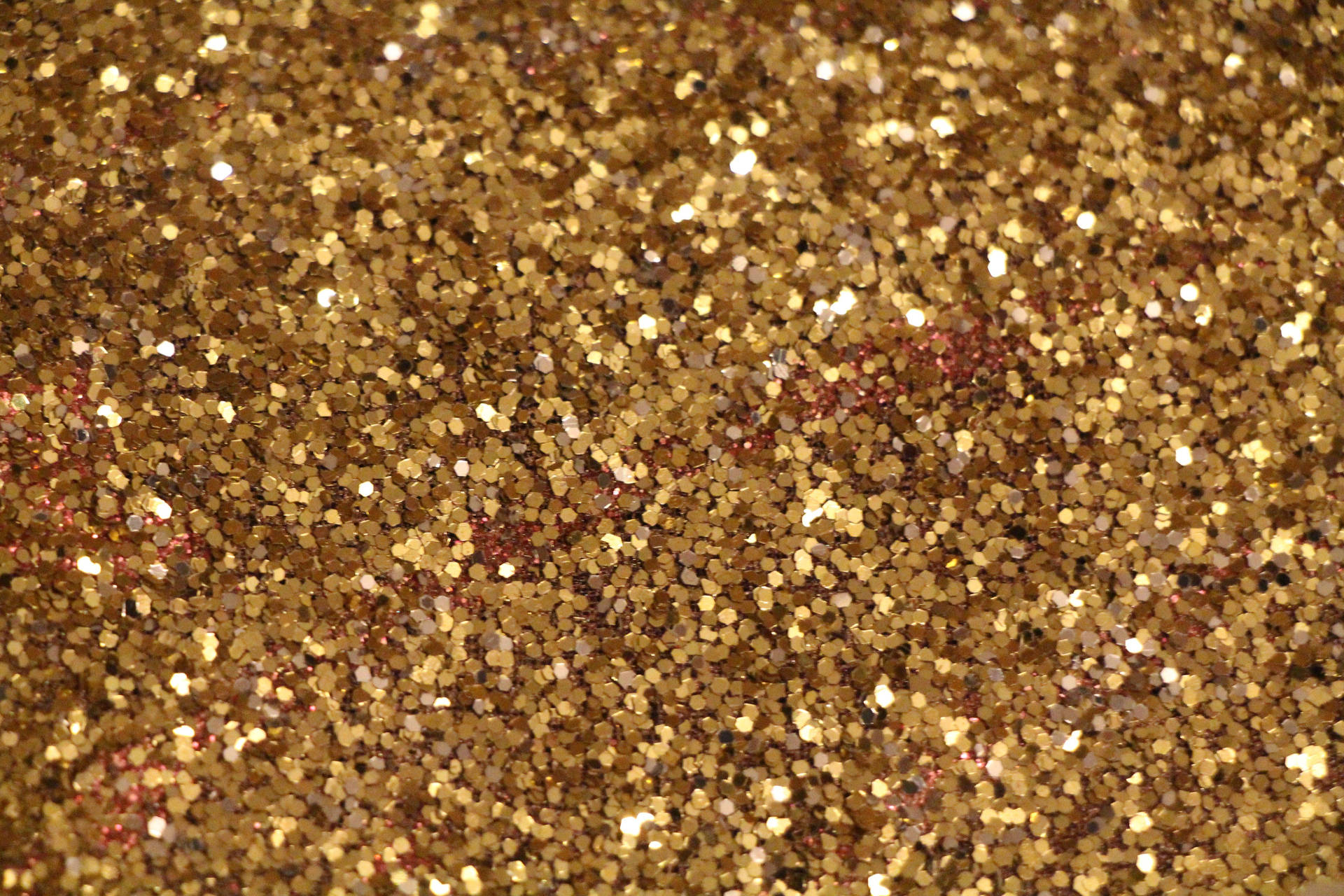 Sparkly 桌布 壁紙 — 閃爍金色亮粉的特寫，散落紅色斑點捕捉光線。