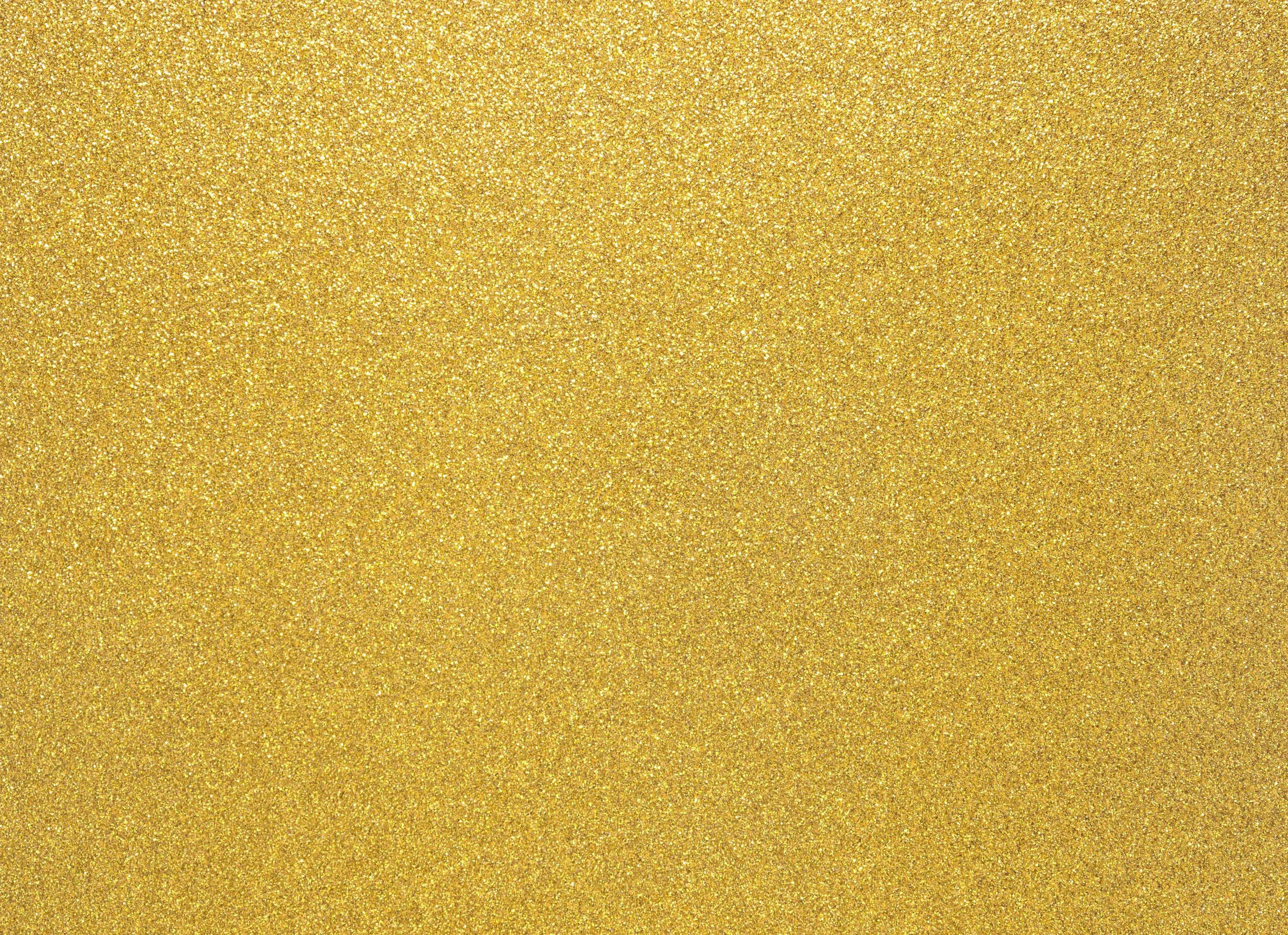 High Resolution Gold Glitter 桌布 壁紙 — 閃爍金色亮粉紋理的近距離特寫，帶有捕捉光線的閃亮顆粒。