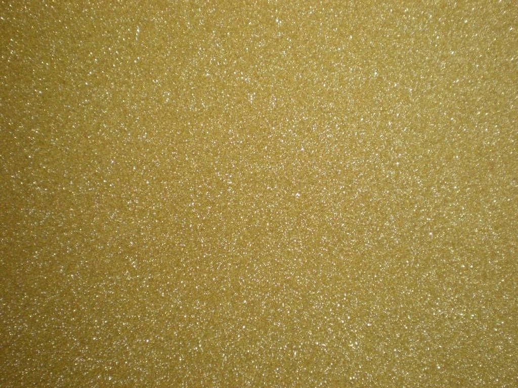 閃爍 桌布 壁紙 — 閃爍金色亮粉紋理的近距離特寫，細小閃亮顆粒散落在溫暖的金屬表面上。
