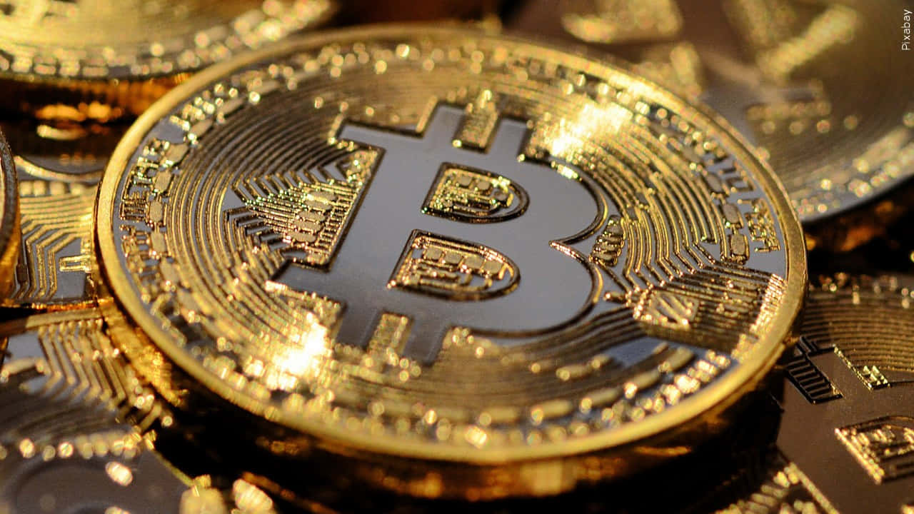 Money 桌布 壁紙 — 閃爍金色比特幣硬幣的特寫，帶有複雜的電路狀雕刻和突出的比特幣符號。
