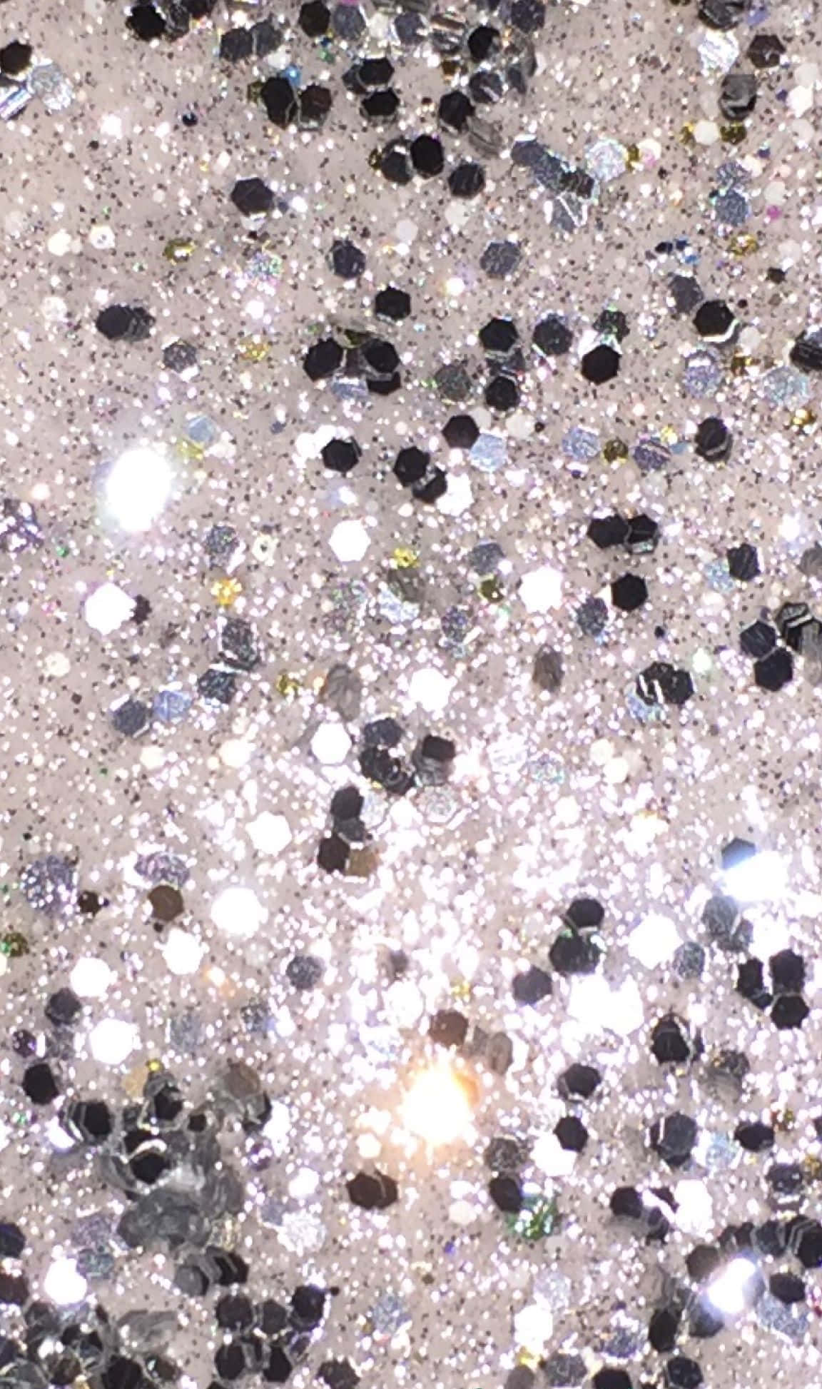 crystals 桌布 壁紙 — 閃爍銀色和黑色亮粉顆粒在淺色背景上捕捉明亮光線的特寫。