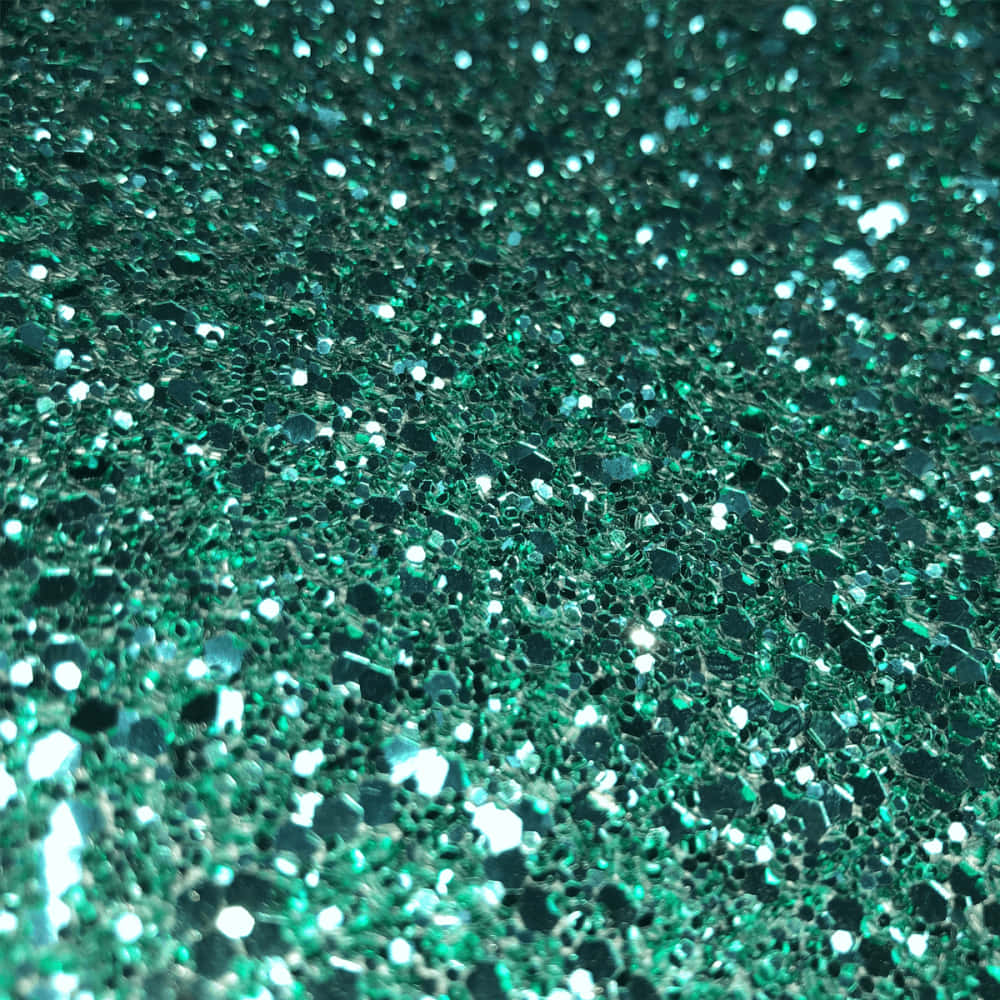 Green Glitter 桌布 壁紙 — 閃爍青綠色亮片的特寫，帶有反射面捕捉明亮光線。