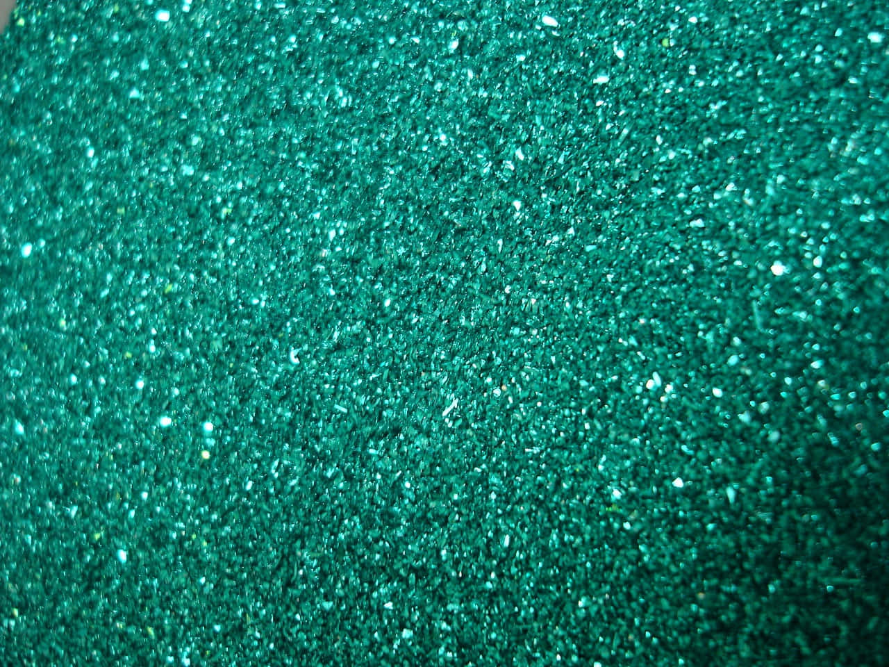 Teal Glitter 桌布 壁紙 — 閃爍青綠色亮片的特寫，帶有捕捉光線的閃亮高光。