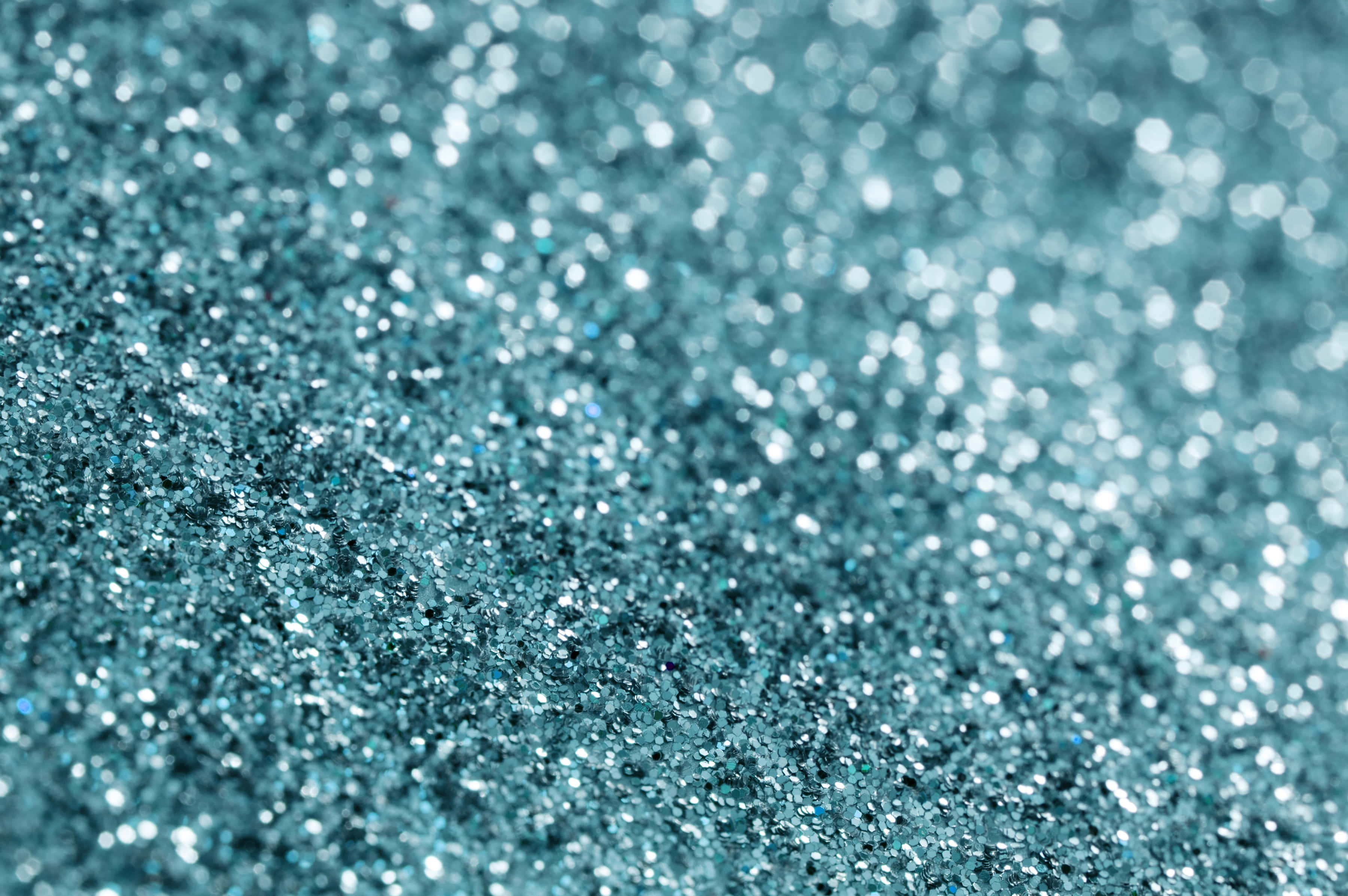 Teal Glitter 桌布 壁紙 — 閃爍青綠色亮粉的特寫，帶有散景高光，營造出閃閃發光的紋理表面。