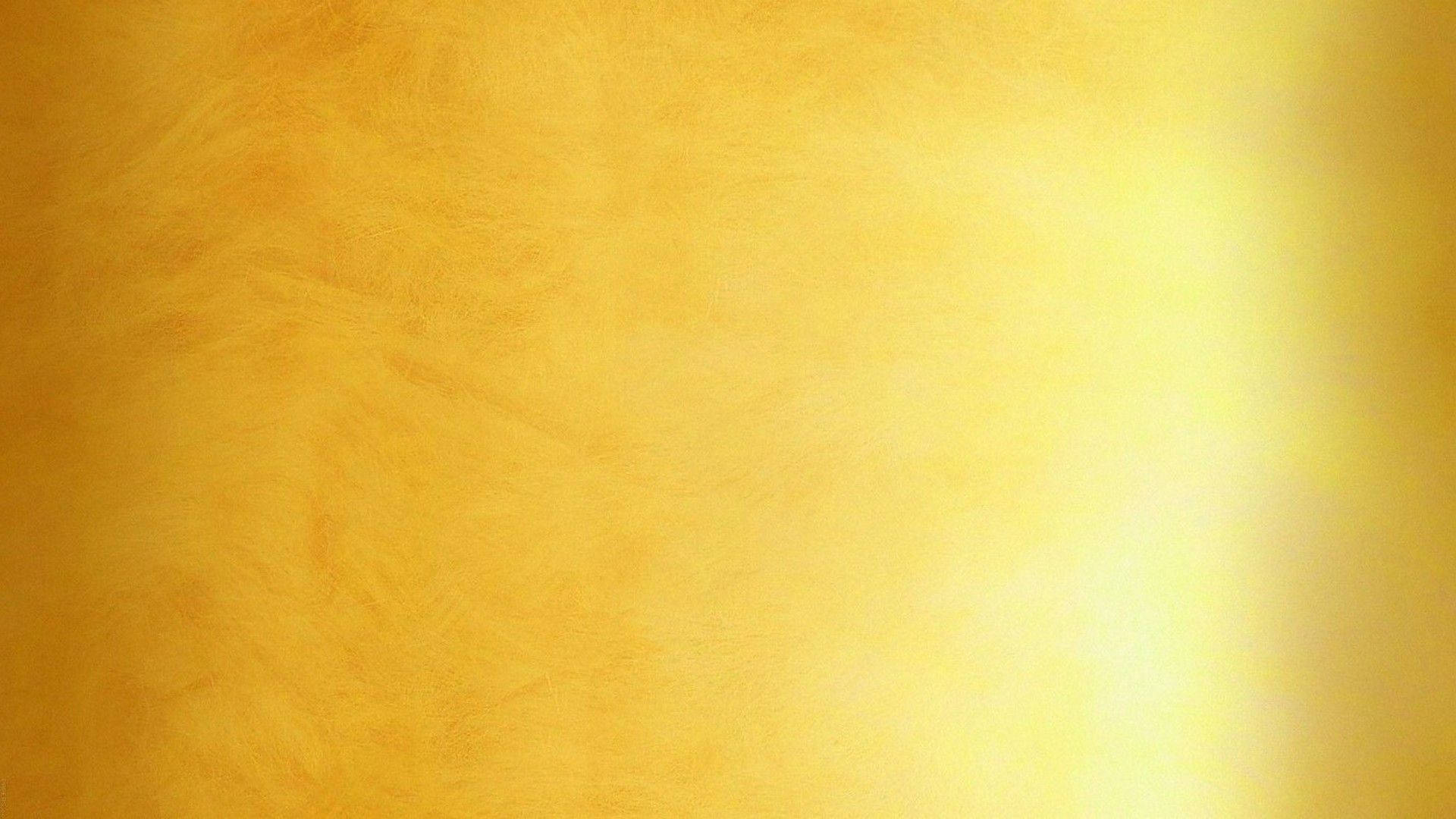 Gold Abstract 桌布 壁紙 — 閃耀的金色紋理表面，帶有柔和漸變和細微的筆觸圖案。
