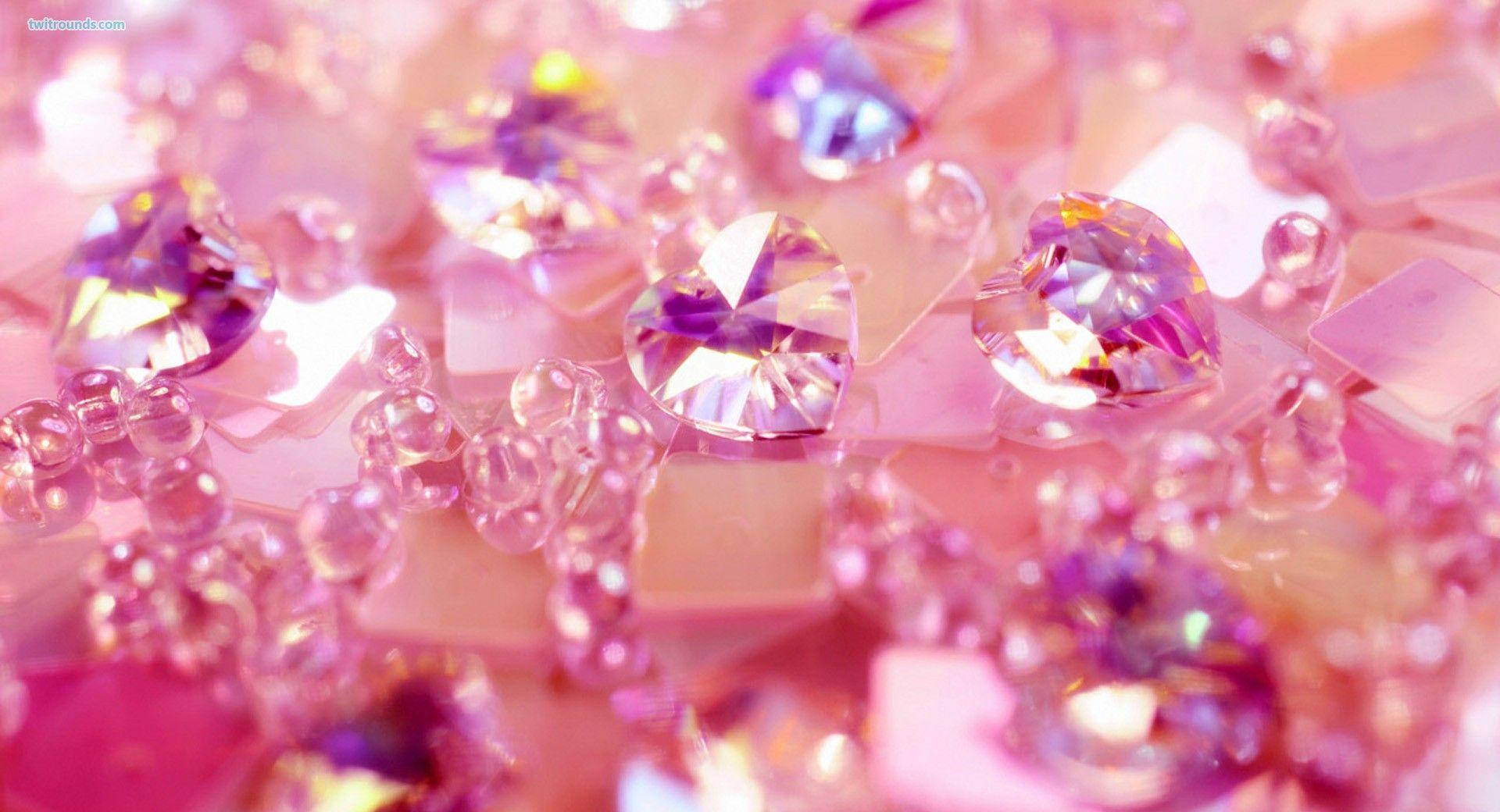 girly pink aesthetic 桌布 壁紙 — 閃閃發光的粉紅色和紫色心形水晶和珠子的特寫，散發著柔和的光芒。