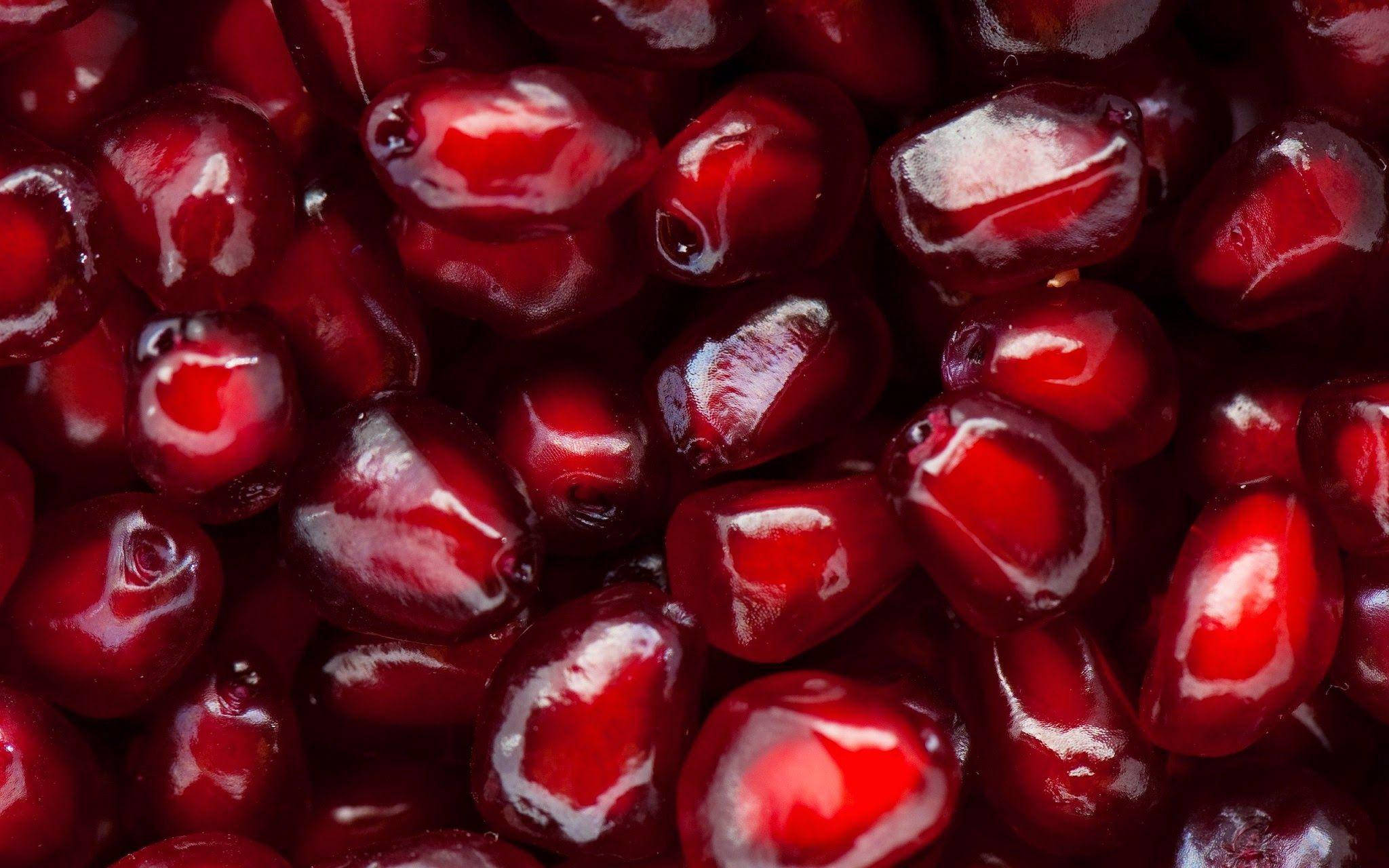 Fruit 桌布 壁紙 — 閃閃發光的紅寶石色石榴籽的特寫，充滿了多汁的甜味。