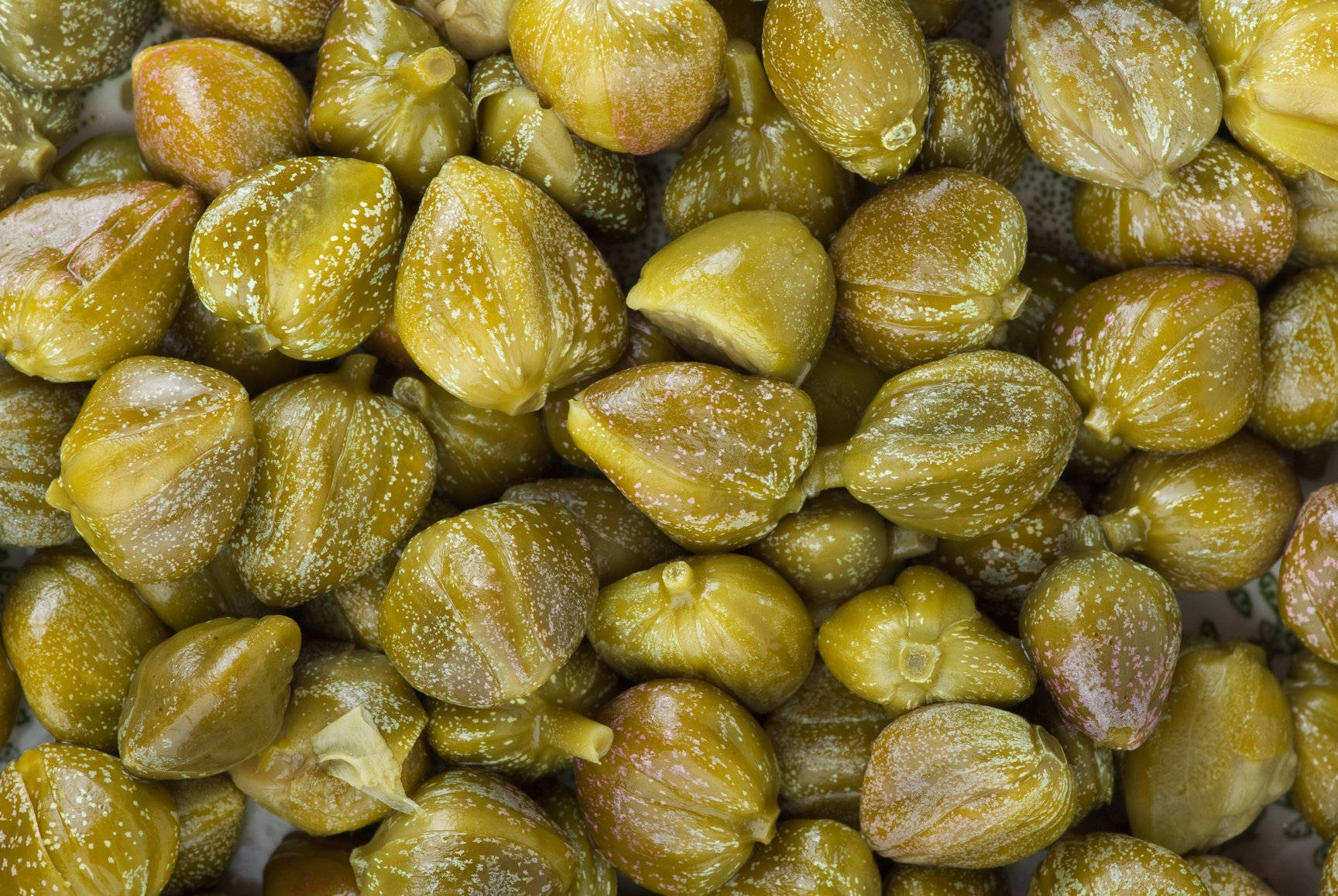Fruit 桌布 壁紙 — 閃閃發光的綠色酸豆特寫，帶有紋理表皮和細微鹽晶。