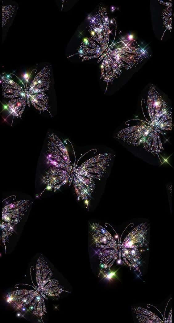 Cool Butterfly 桌布 壁紙 — 閃閃發光的蝴蝶飾以閃爍寶石，在深邃的黑色虛空中漂浮，散發出鮮豔的彩虹光芒。