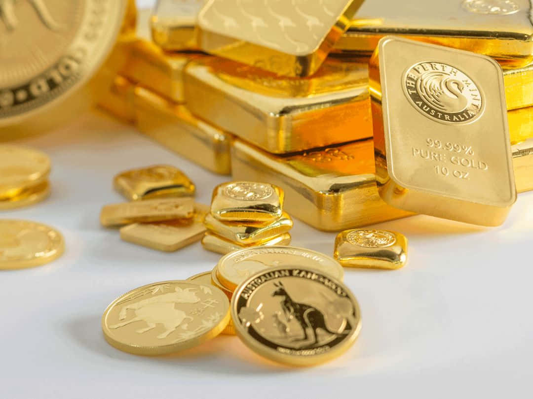 金錢 桌布 壁紙 — 閃閃發光的金條堆和散落的澳洲金幣在潔白的表面上反射光線。