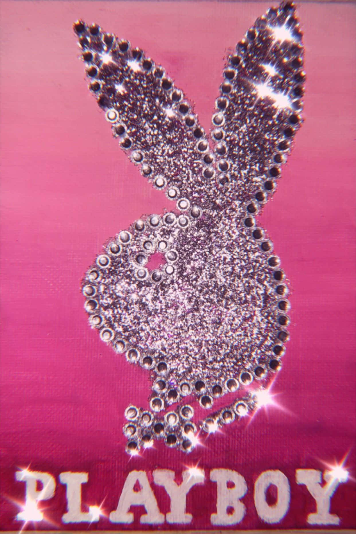 Playboy Aesthetic 桌布 壁紙 — 閃閃發光的銀色水鑽Playboy兔子標誌在充滿活力的粉紅色布料背景上閃爍，下方有PLAYBOY字樣。