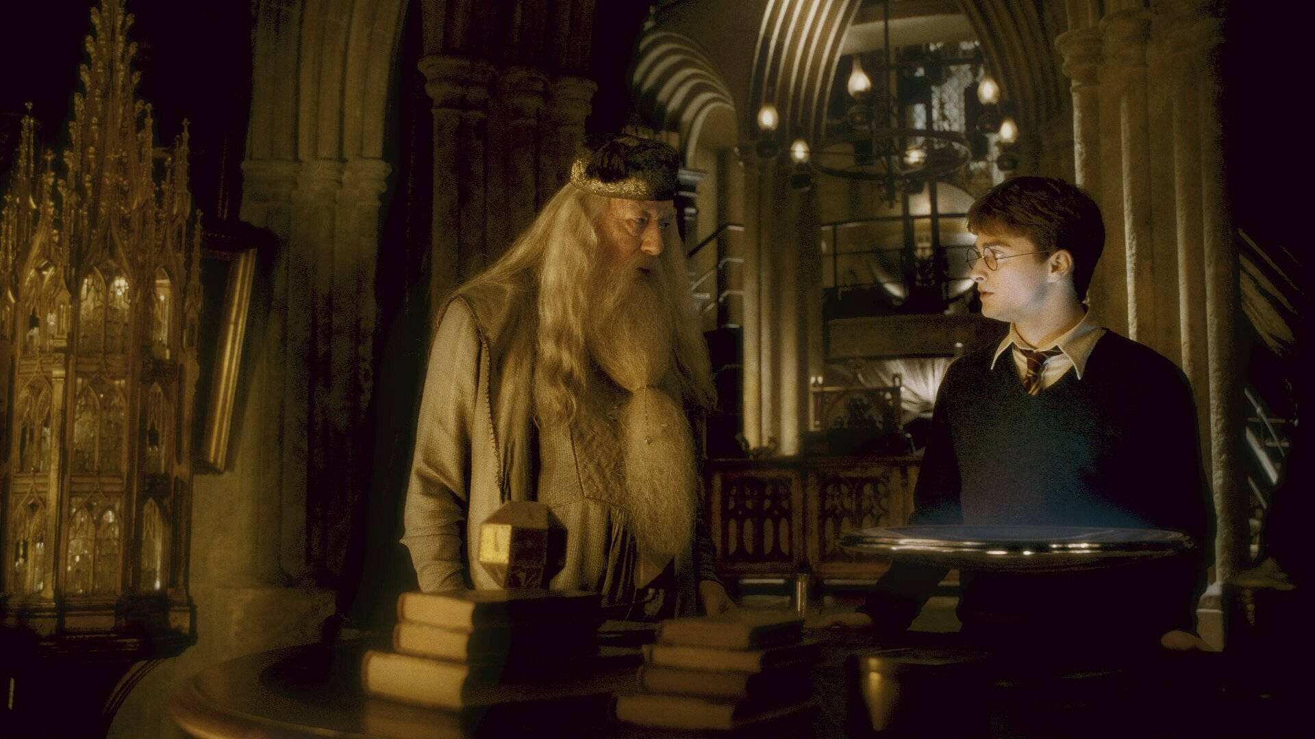 dumbledore 桌布 壁紙 — 阿不思·鄧不利多和哈利·波特在一個燈光昏暗、裝飾華麗的哥德式圖書館中面對面，周圍是高聳的書架和溫暖的燭光。