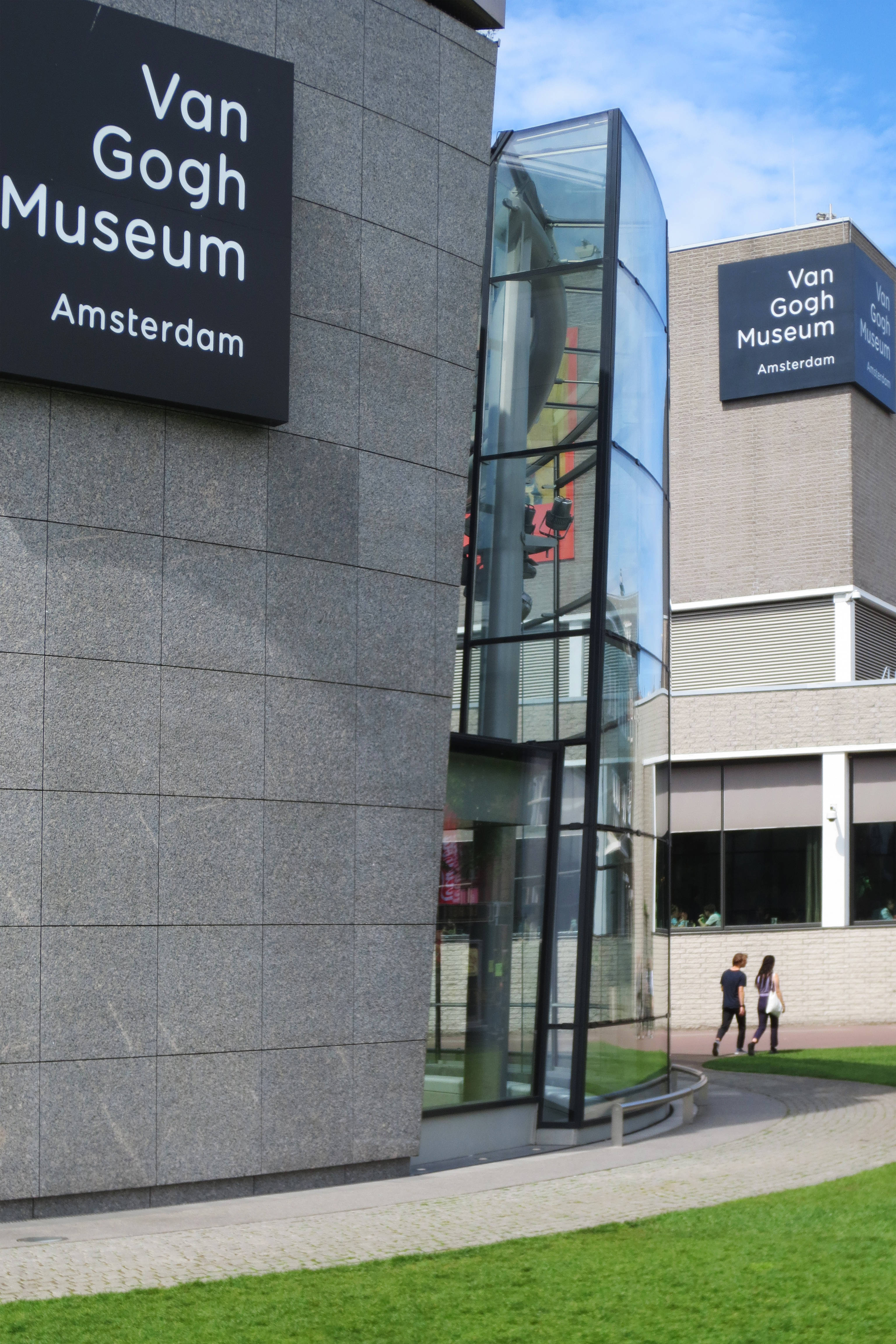 Museum 桌布 壁紙 — 阿姆斯特丹梵谷博物館的現代玻璃和石頭建築，陽光普照的日子裡有行人。