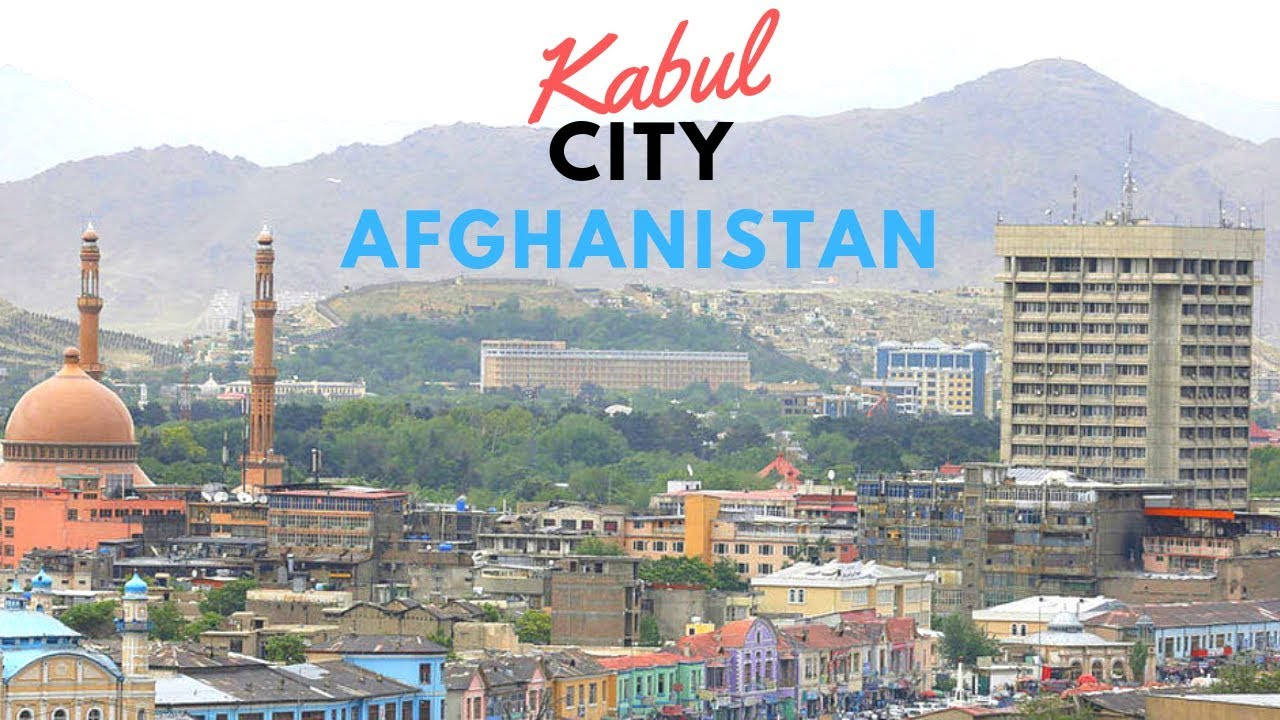 Kabul 桌布 壁紙 — 阿富汗喀布爾的全景，展示在朦朧天空下的彩色建築、清真寺和山脈。