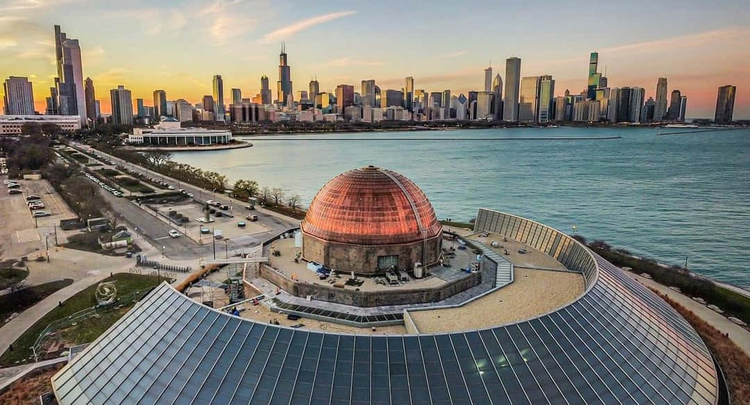 Planetarium 桌布 壁紙 — 阿德勒天文館的鳥瞰圖，銅製圓頂在日落時分在芝加哥天際線和密西根湖的映襯下閃閃發光。