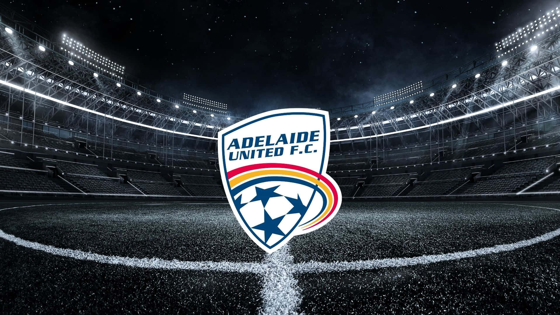 Adelaide United 桌布 壁紙 — 阿德萊德聯足球俱樂部標誌在球場中央，於球場燈光下，以繁星點點的夜空為背景發光。