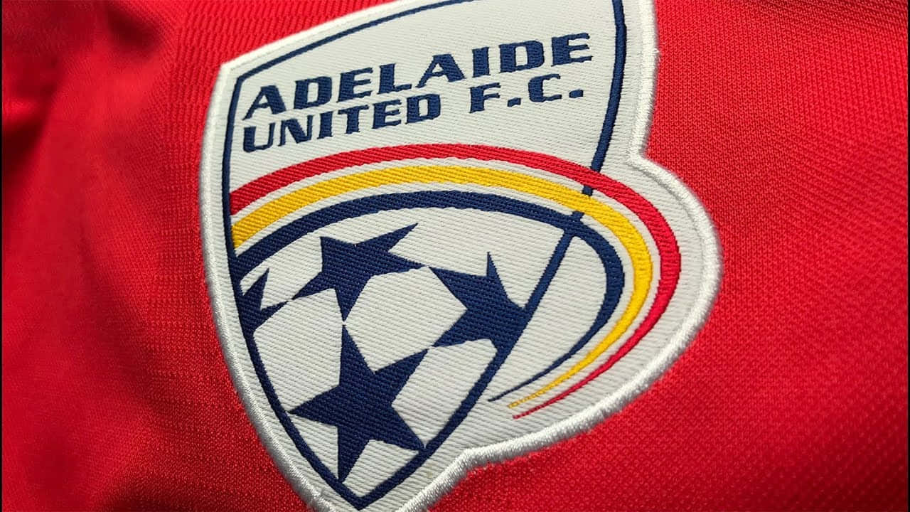 Adelaide United 桌布 壁紙 — 阿德萊德聯足球會刺繡會徽在紅色足球球衣布料上的特寫。