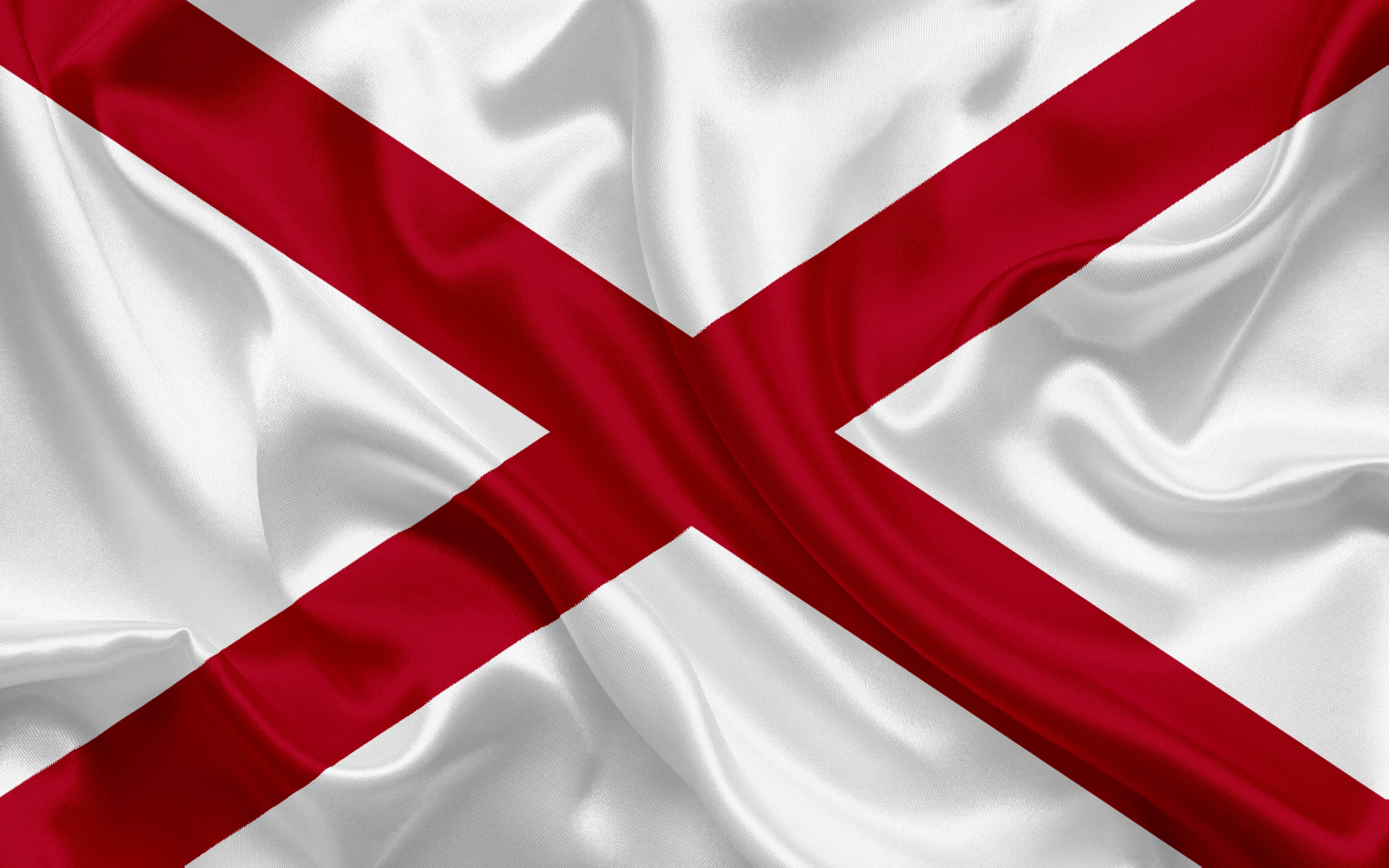 Alabama 桌布 壁紙 — 阿拉巴馬州旗的特寫，白色布料上有鮮明的紅色十字，呈現逼真的摺痕和光澤。