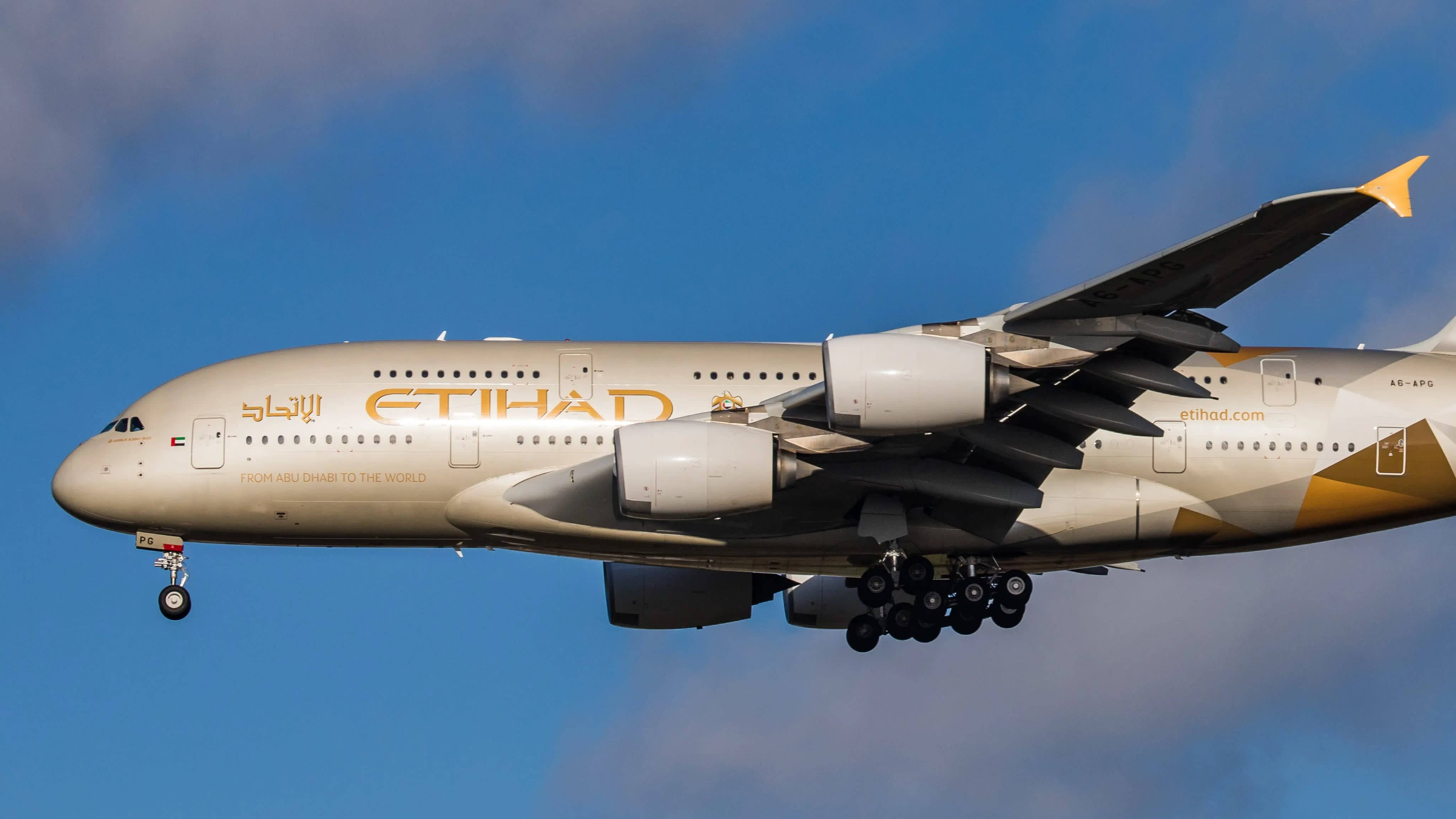 flying 桌布 壁紙 — 阿提哈德航空的空中巴士A380以金色塗裝，在晴朗的藍天中翱翔，起落架已放下。