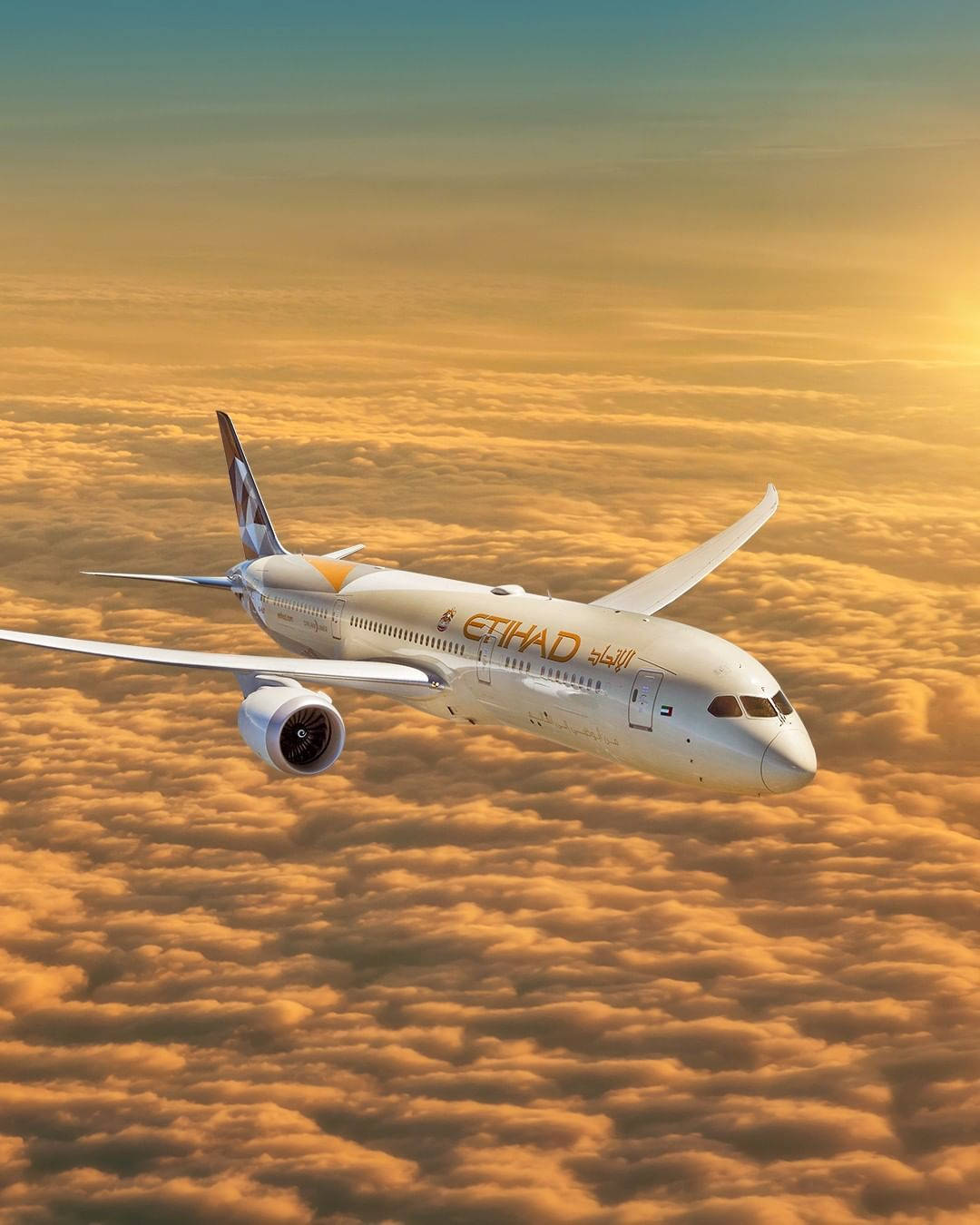 flying 桌布 壁紙 — 阿提哈德航空的飛機在溫暖夕陽光輝沐浴的金色雲海上優雅翱翔。
