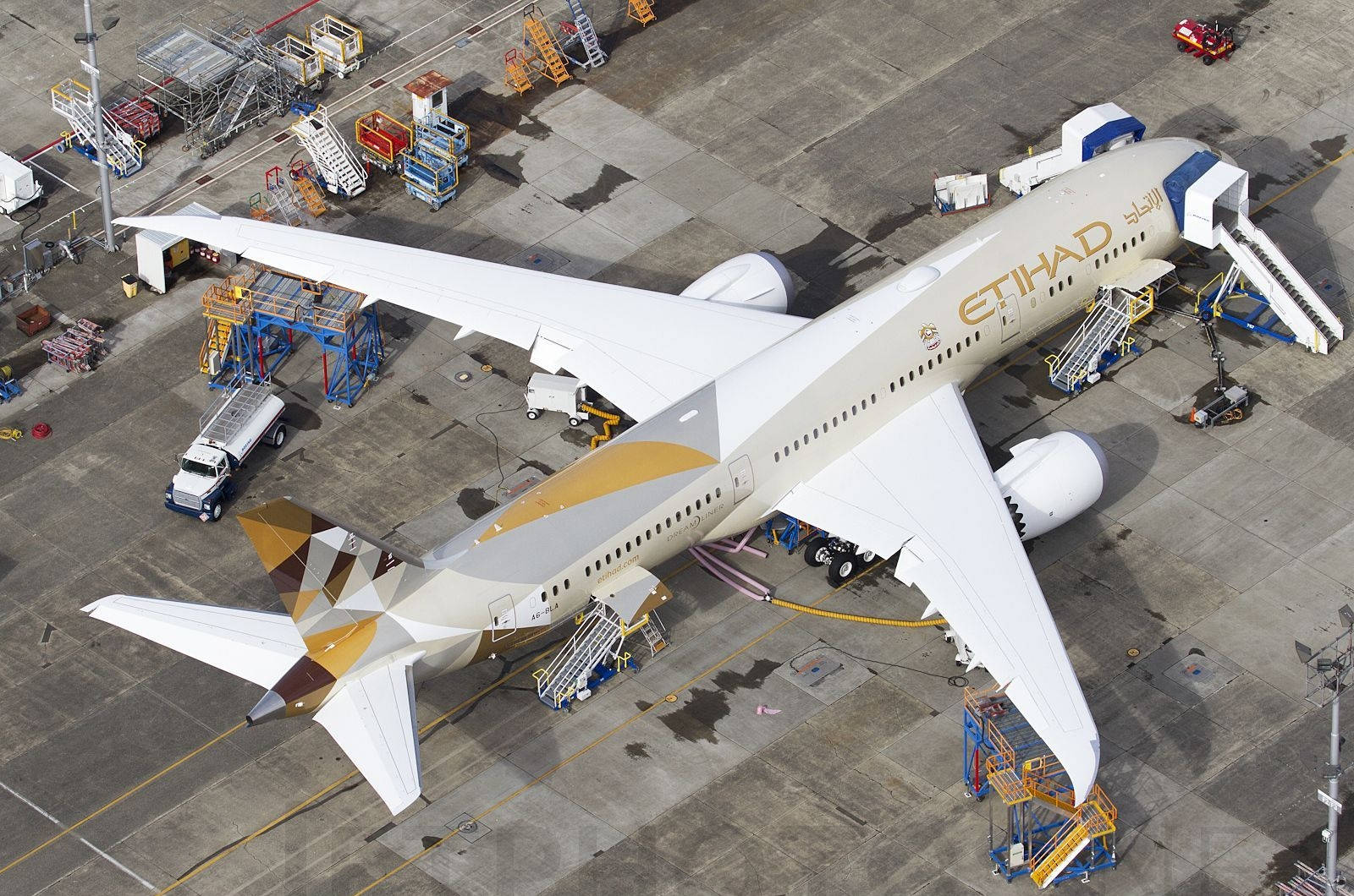 Airport 桌布 壁紙 — 阿提哈德航空空中巴士A350停泊在機場閘口，周圍有地面服務設備的鳥瞰圖。