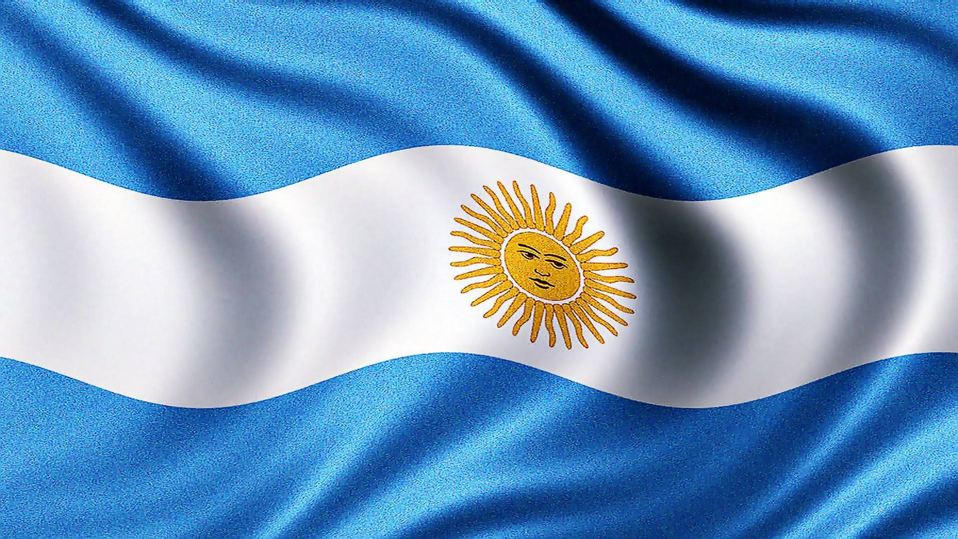 Argentina 桌布 壁紙 — 阿根廷國旗動態飄揚，帶有豐富的藍白條紋和中央發光的金色太陽標誌。