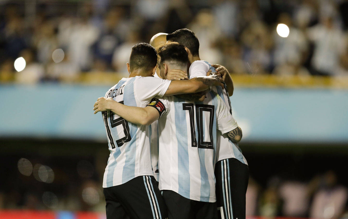 Argentina 桌布 壁紙 — 阿根廷足球運動員身穿藍白間條球衣，在球場燈光下圍成一團慶祝。