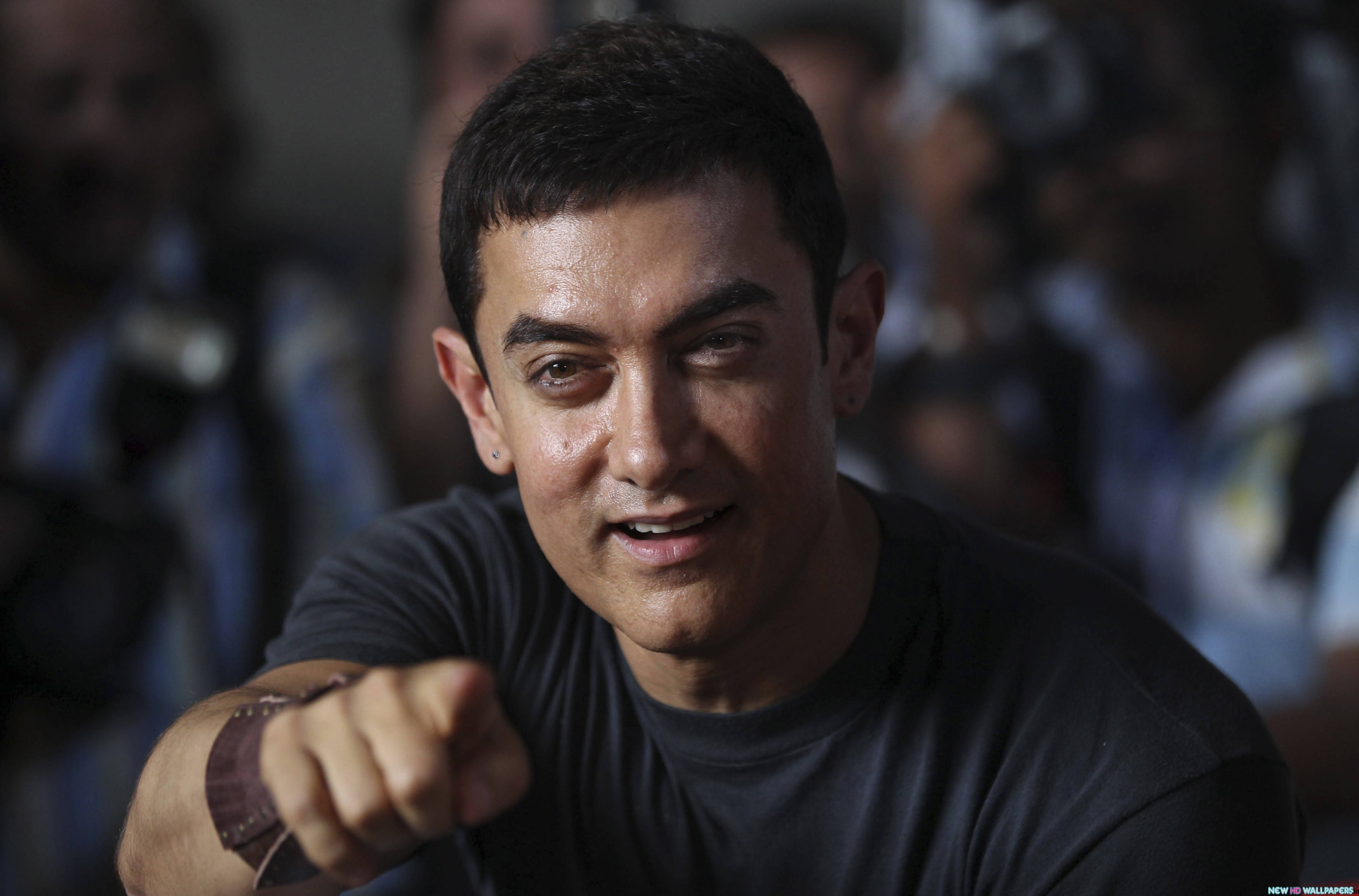 Aamir Khan 桌布 壁紙 — 阿米爾汗自信地微笑著指向前方，周圍是模糊的攝影師。