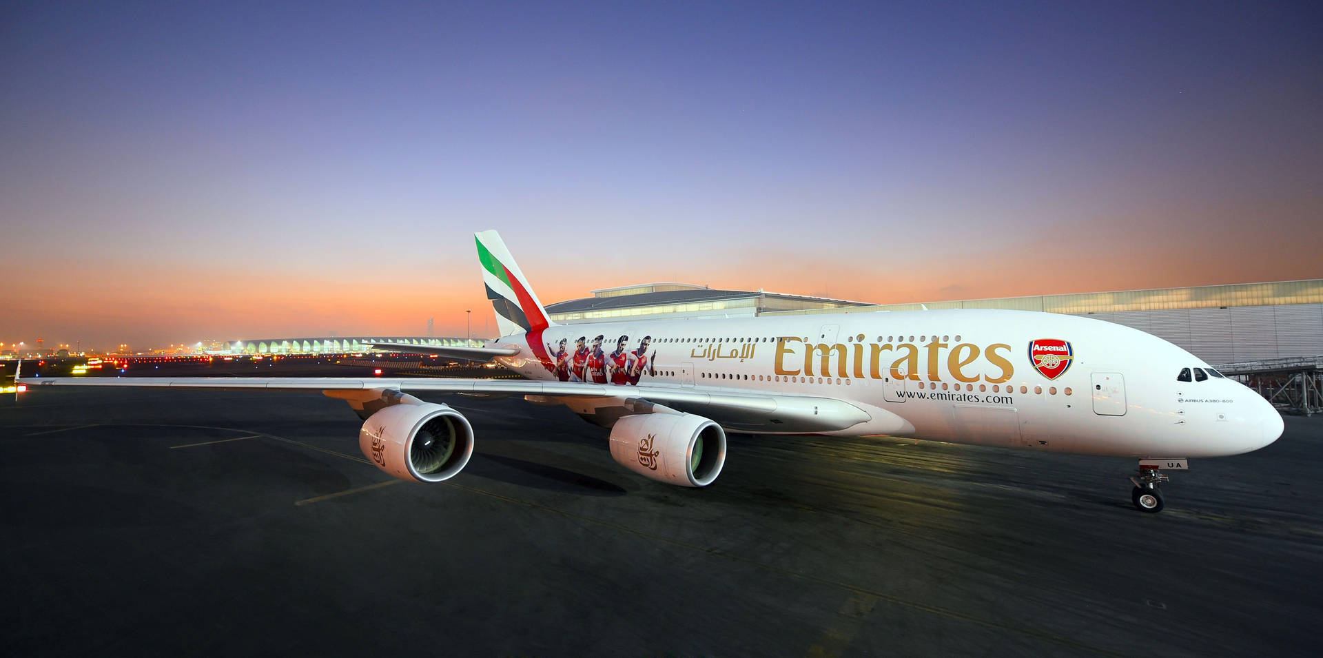 阿聯酋航空空中巴士A380披上兵工廠塗裝，在日落時分的機場停機坪上。
