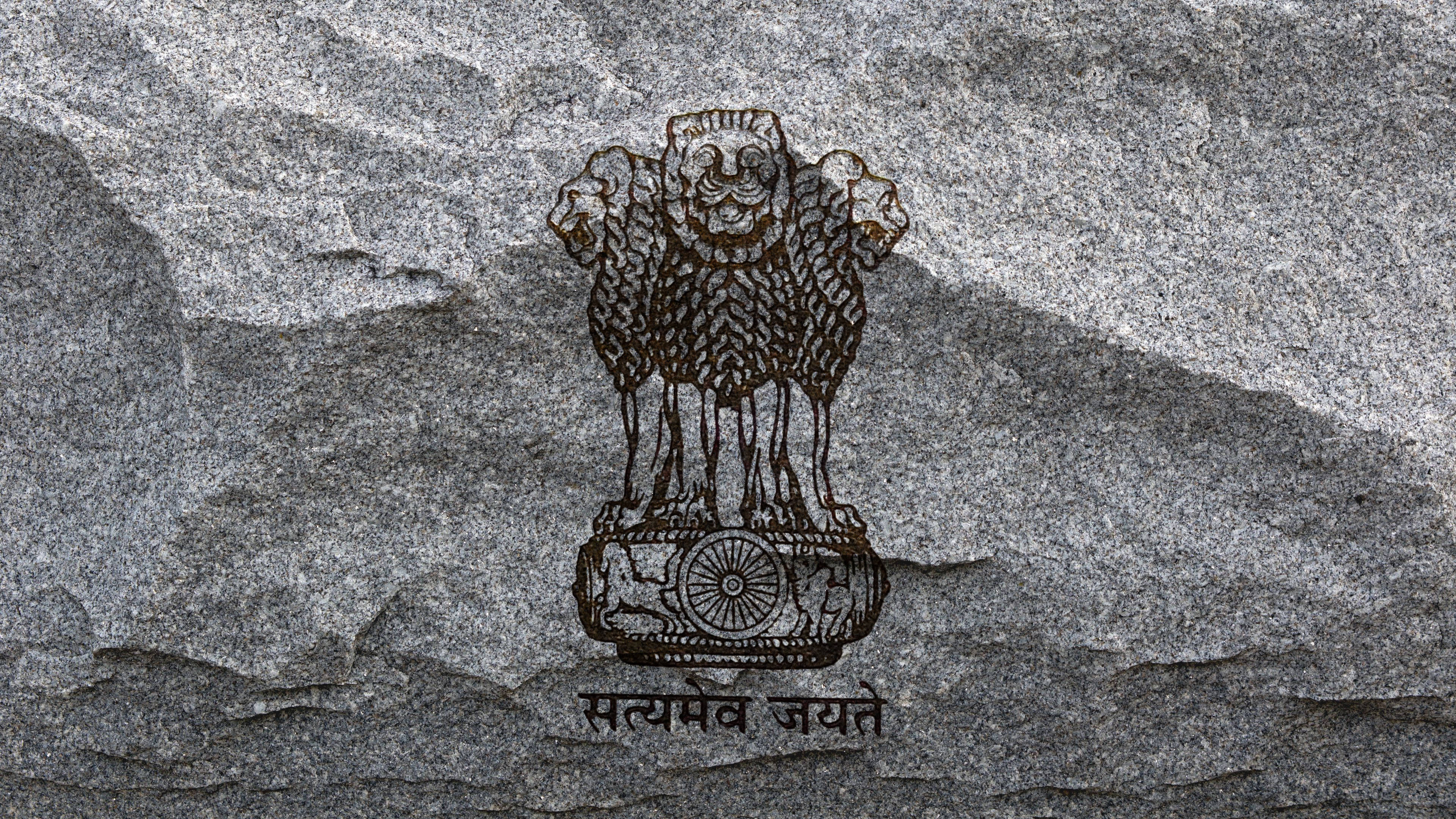 upsc 桌布 壁紙 — 阿育王獅子柱頭以深棕色雕刻在紋理灰色石頭上，下方有梵文格言。