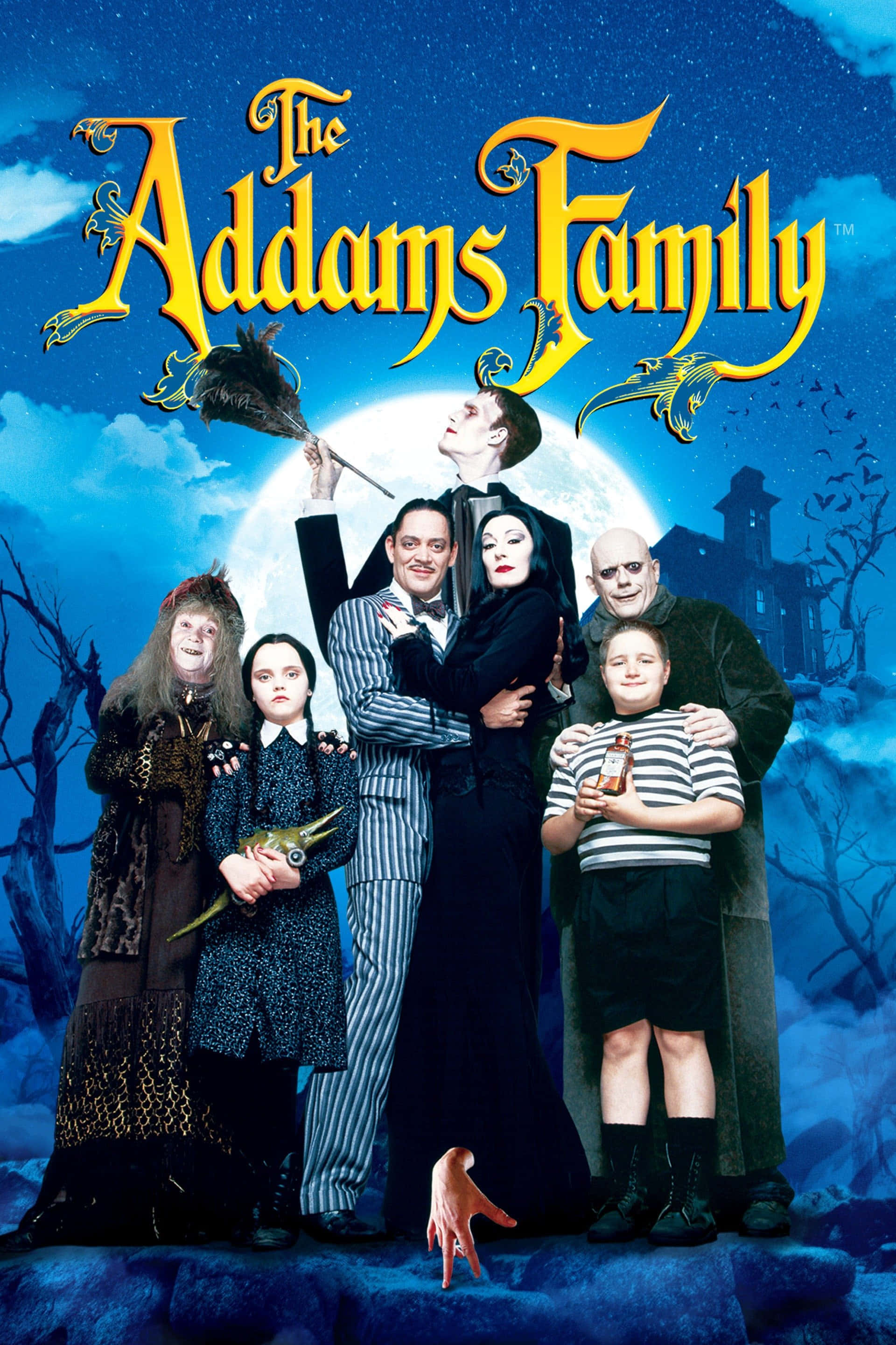 Addams Family 桌布 壁紙 — 阿達一族在滿月下一起站在一個陰森哥德式庭院中，背景有光禿禿的樹木和一座鬼屋大宅。