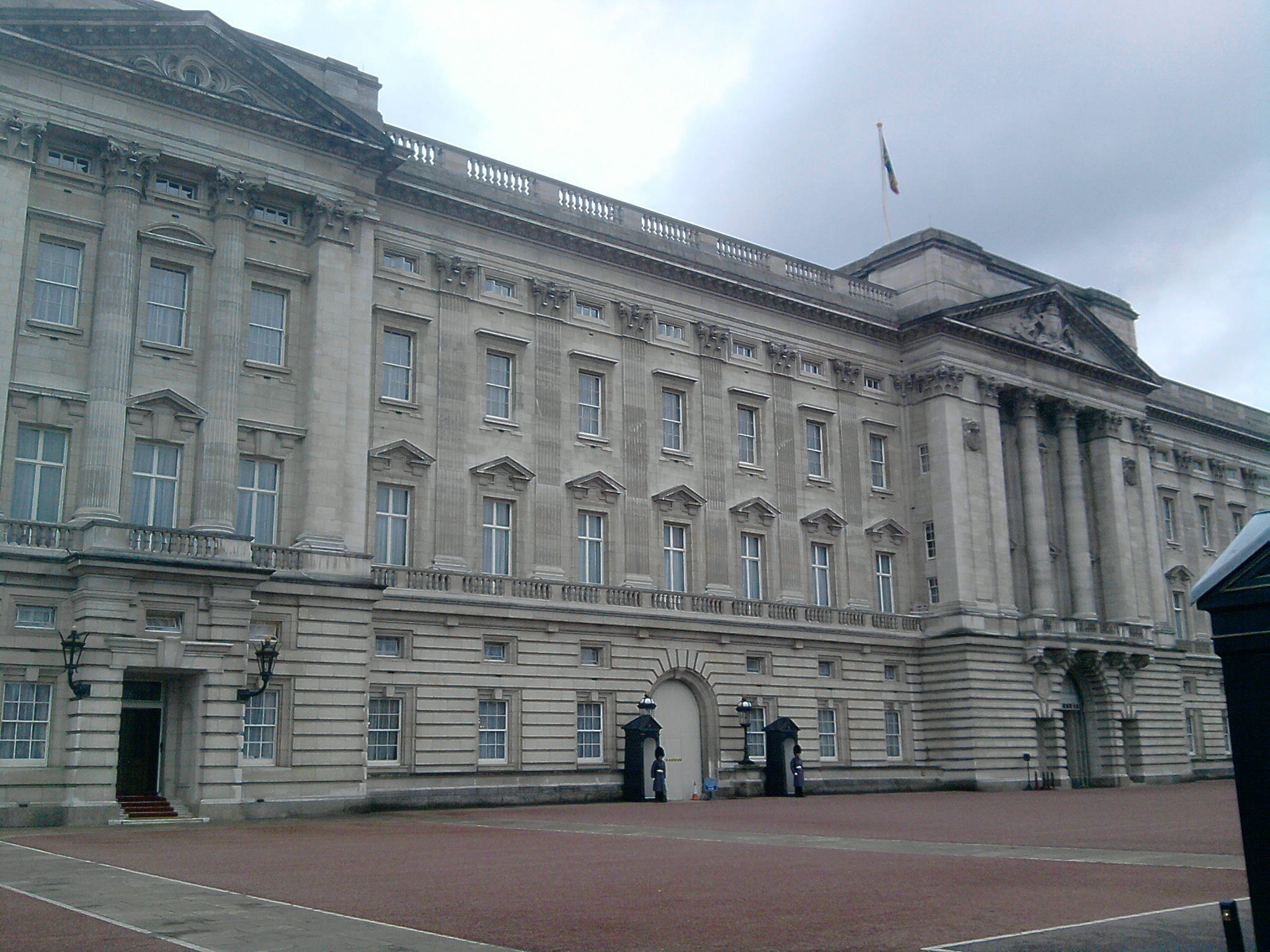 England 桌布 壁紙 — 陰天下，宏偉的新古典主義宮殿，配有石柱和旗幟。