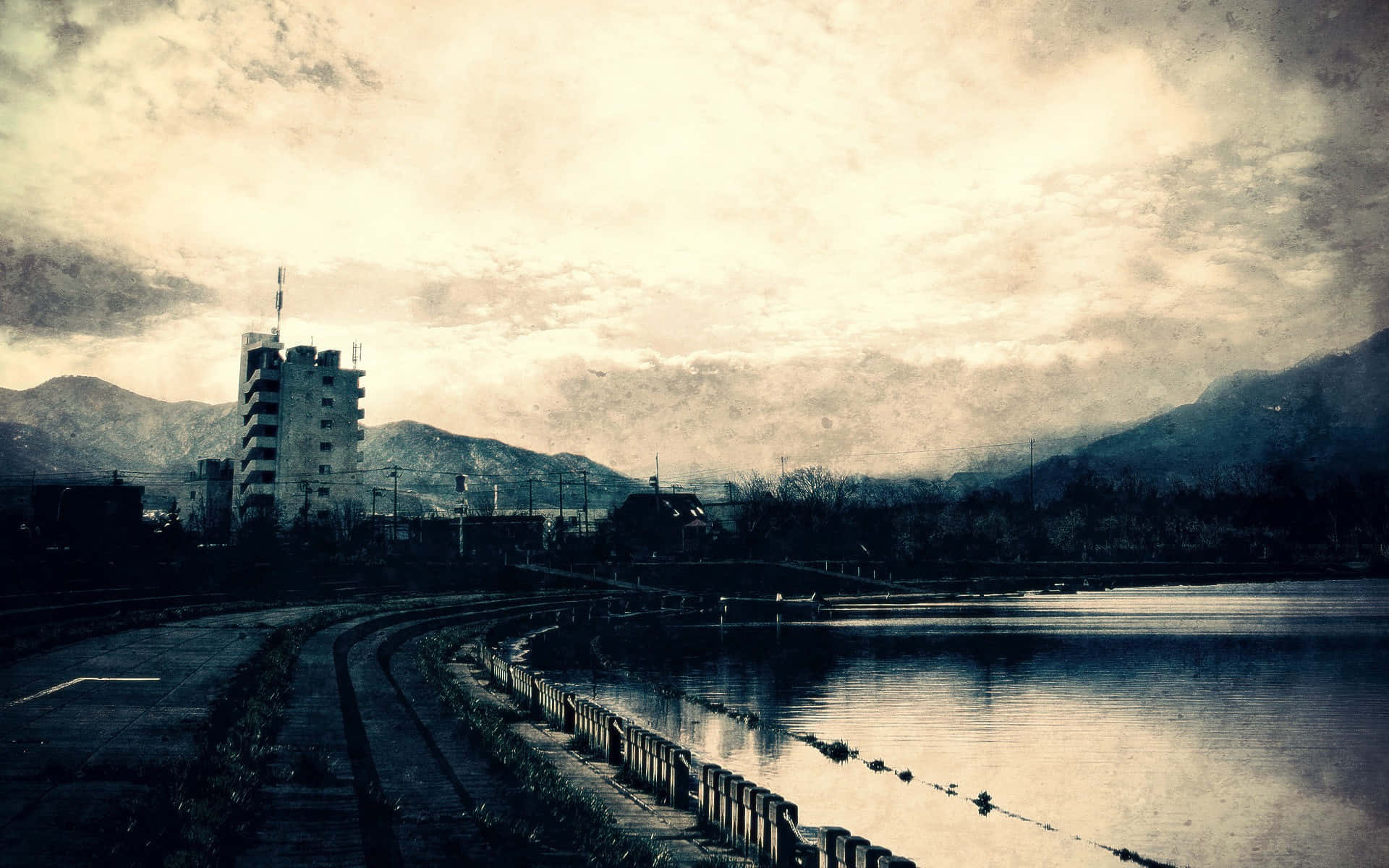 Post Apocalyptic 桌布 壁紙 — 陰天下一座孤獨建築物和火車軌道的憂鬱城市河畔場景。