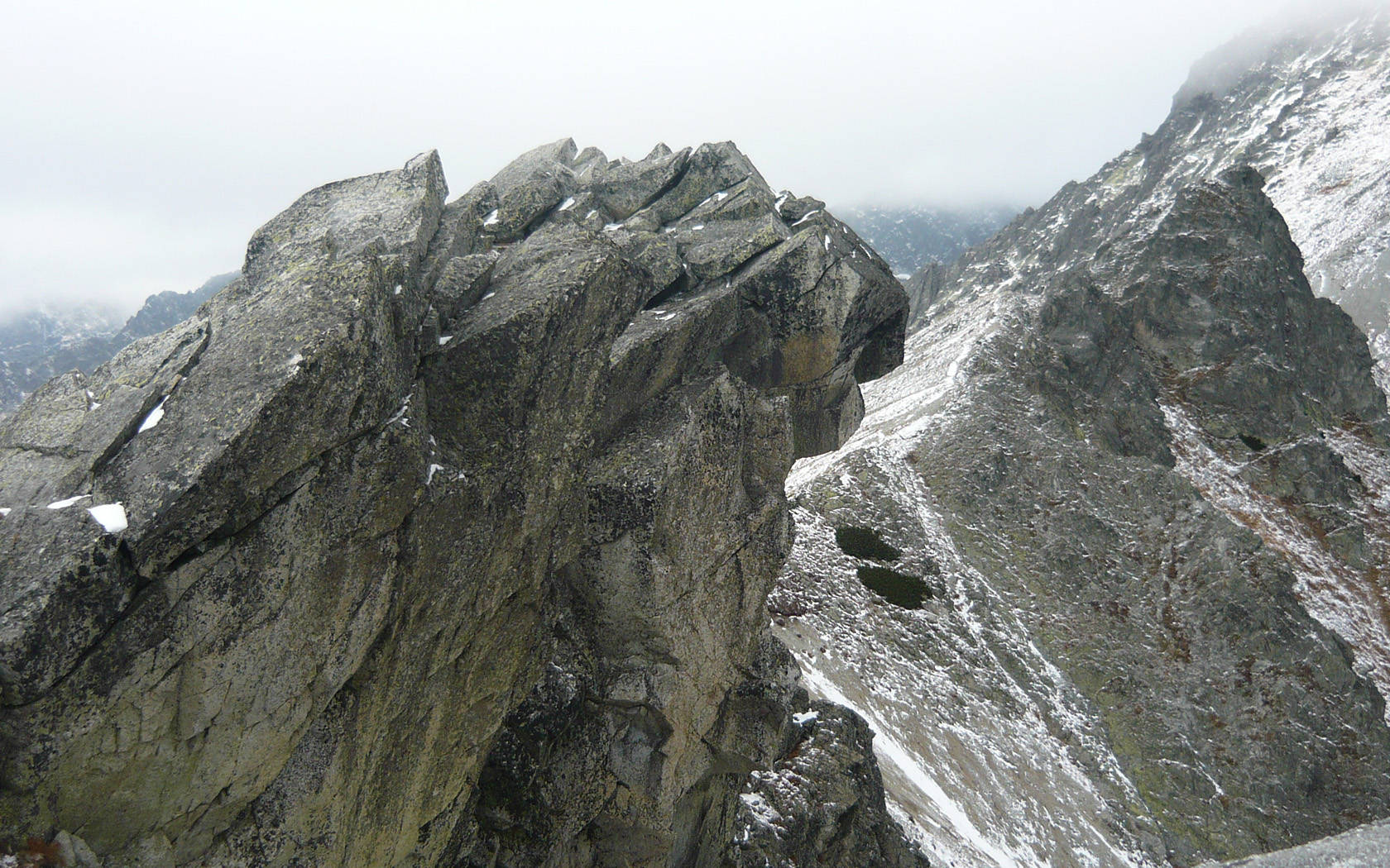 Slovakia 桌布 壁紙 — 陰天下一座崎嶇的岩石山峰，帶有片片積雪。