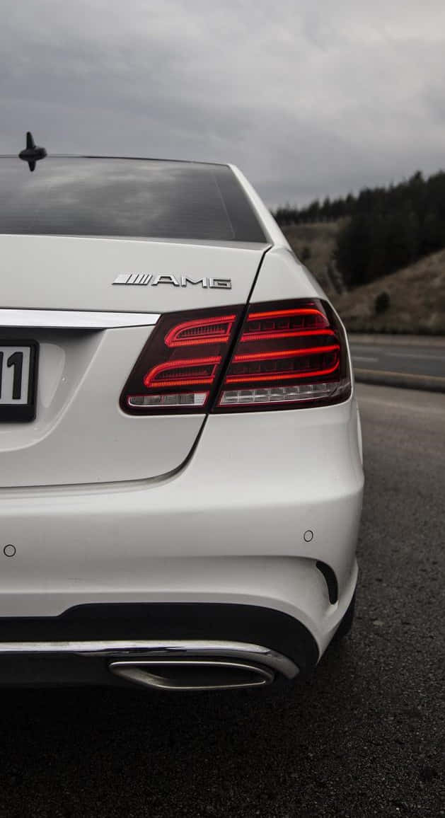 賓士 iPhone 桌布 壁紙 — 陰天時，白色 Mercedes-AMG 汽車後部及發光紅色尾燈的特寫。