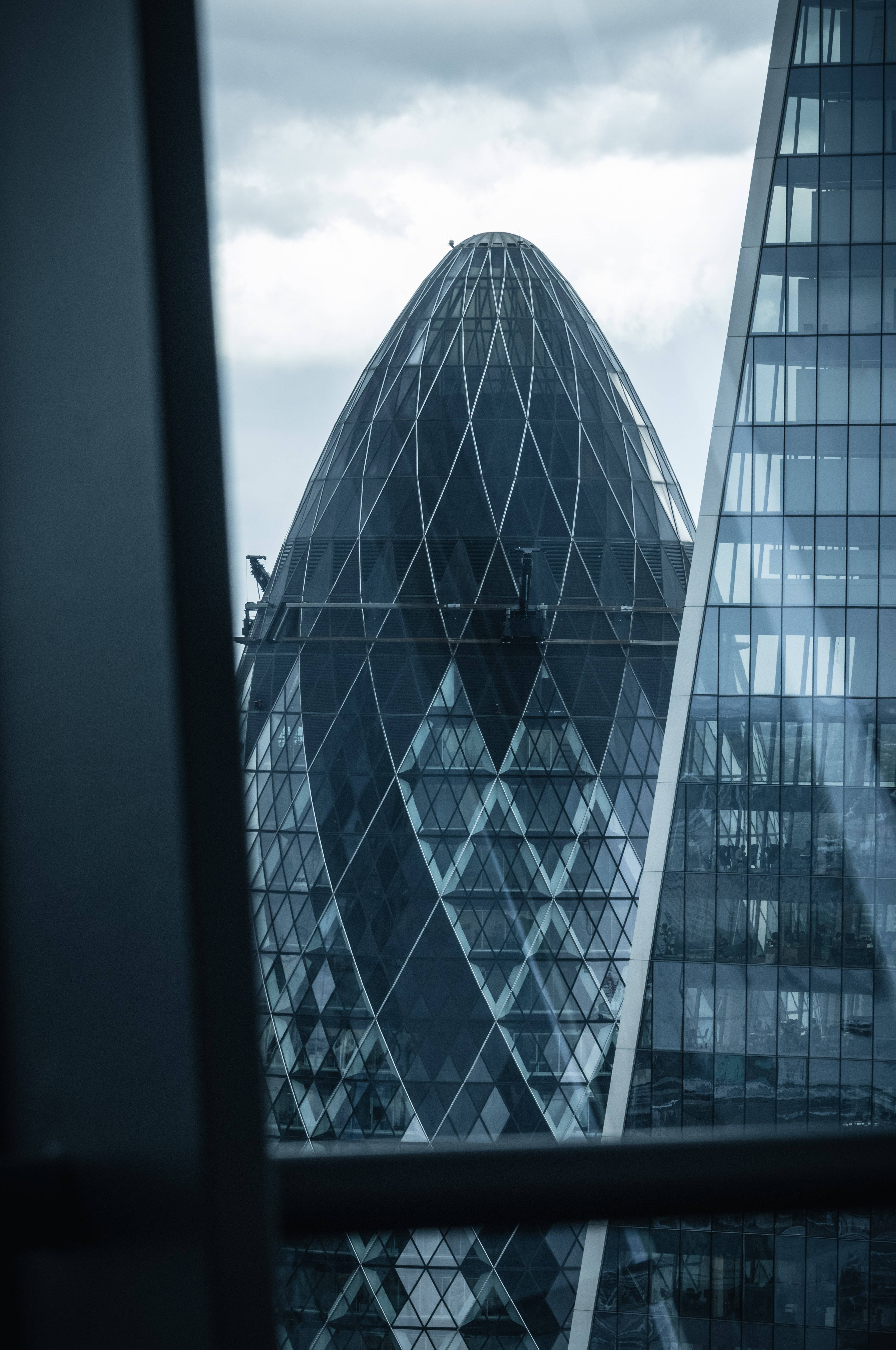 手機 桌布 壁紙 — 陰天時透過窗框欣賞Gherkin摩天大樓的陰鬱景觀。