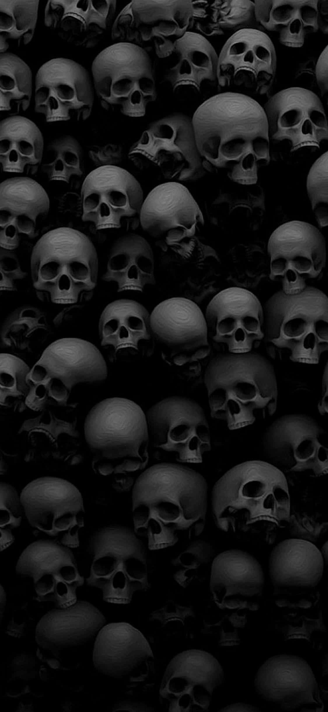 Spooky iPhone 桌布 壁紙 — 陰影中密集的灰色頭骨牆營造出令人不安和壓抑的氛圍。