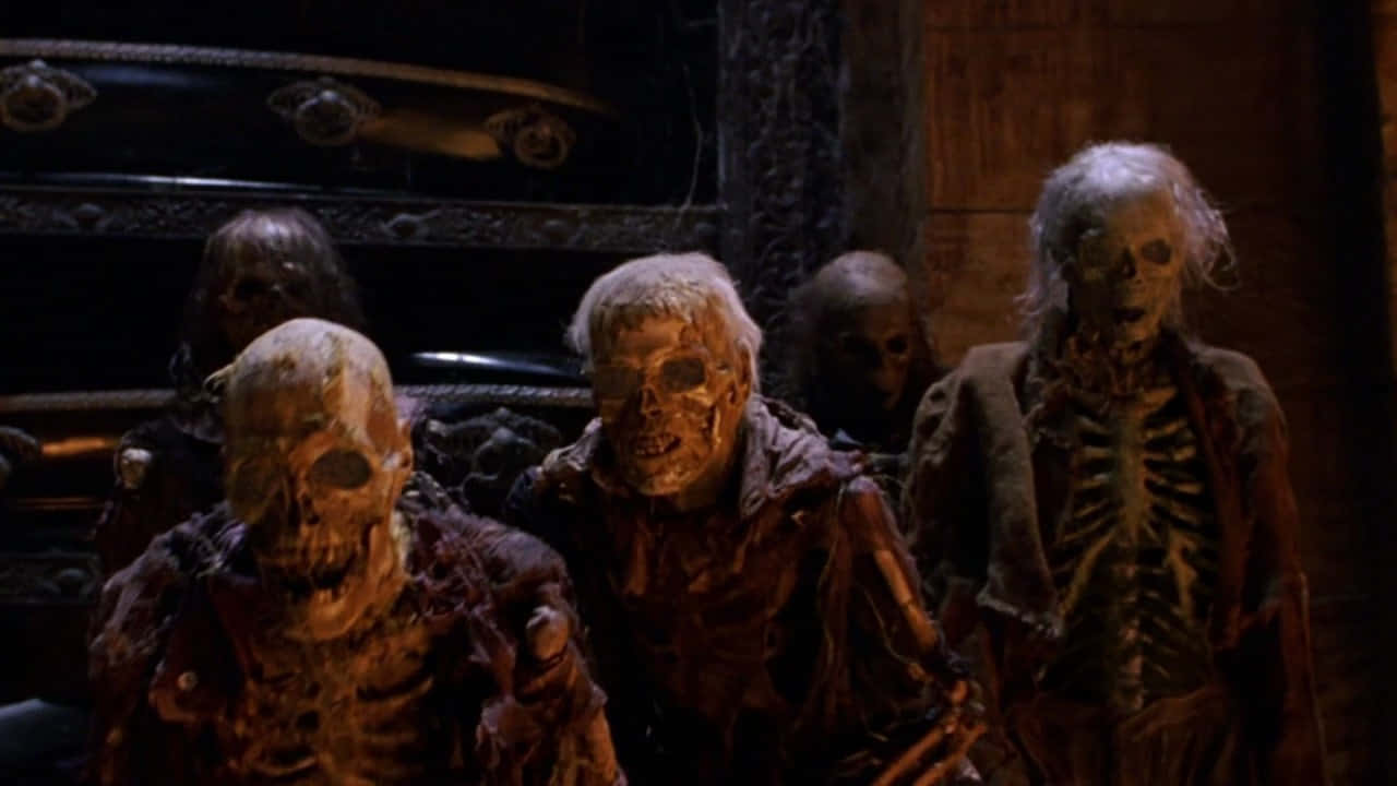 Scary Zombie 桌布 壁紙 — 陰森的復活骷髏穿著破爛長袍，站在昏暗的地窖中，身後有華麗的棺材。