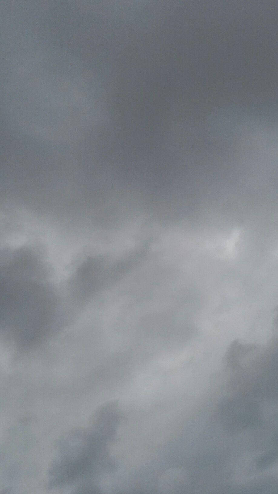 Aesthetic Cute Pastel 桌布 壁紙 — 陰沉的天空佈滿濃密的灰色雲層，遠方有一絲微弱的光線穿透而出。