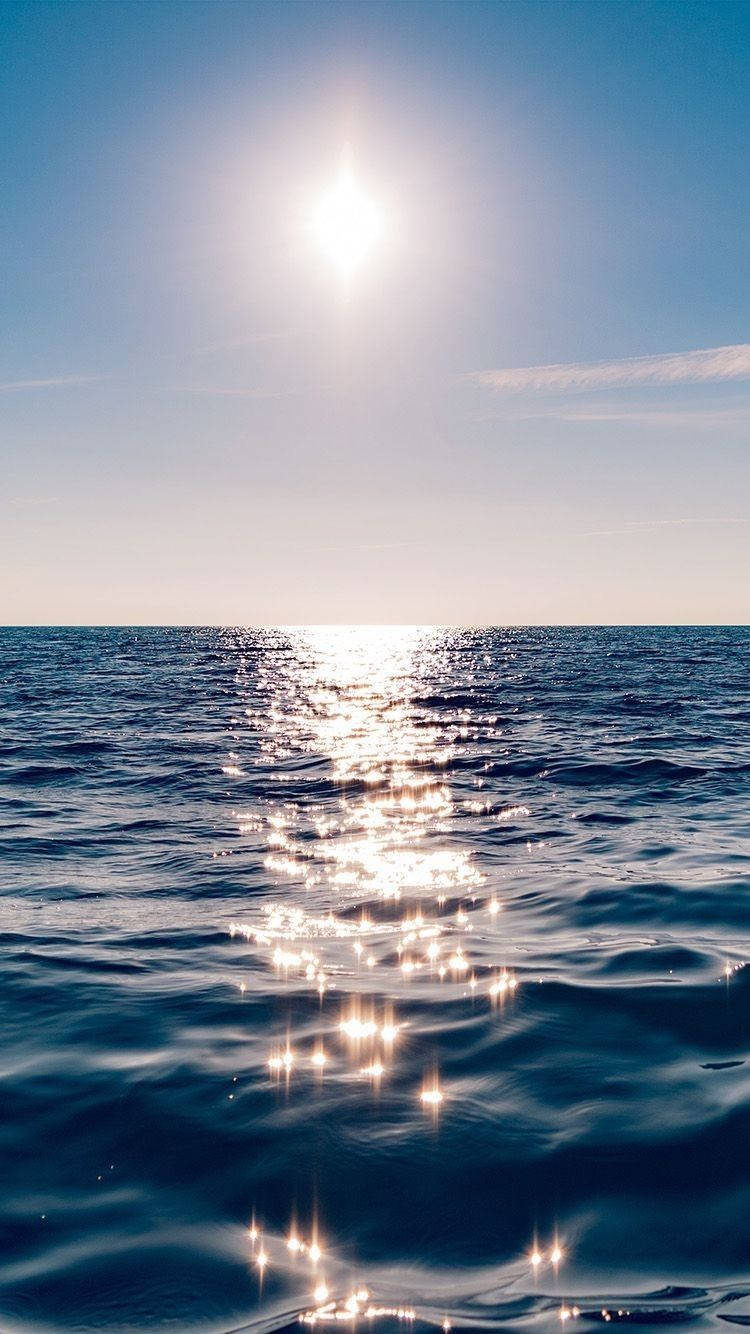 陽光在晴朗的藍天下反射在平靜的海面上。