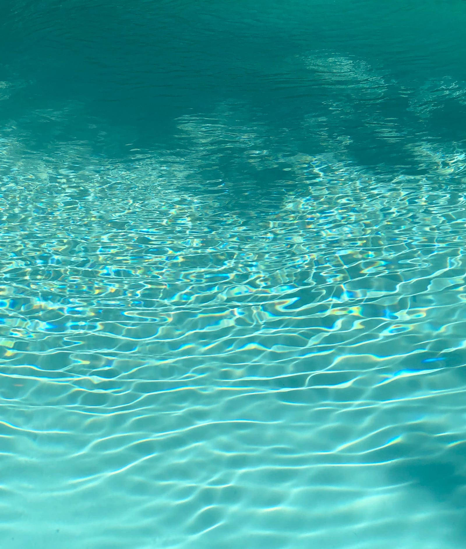 Cool Water 桌布 壁紙 — 陽光在泛起漣漪的碧綠水面上舞動，在水面下形成閃爍的圖案。