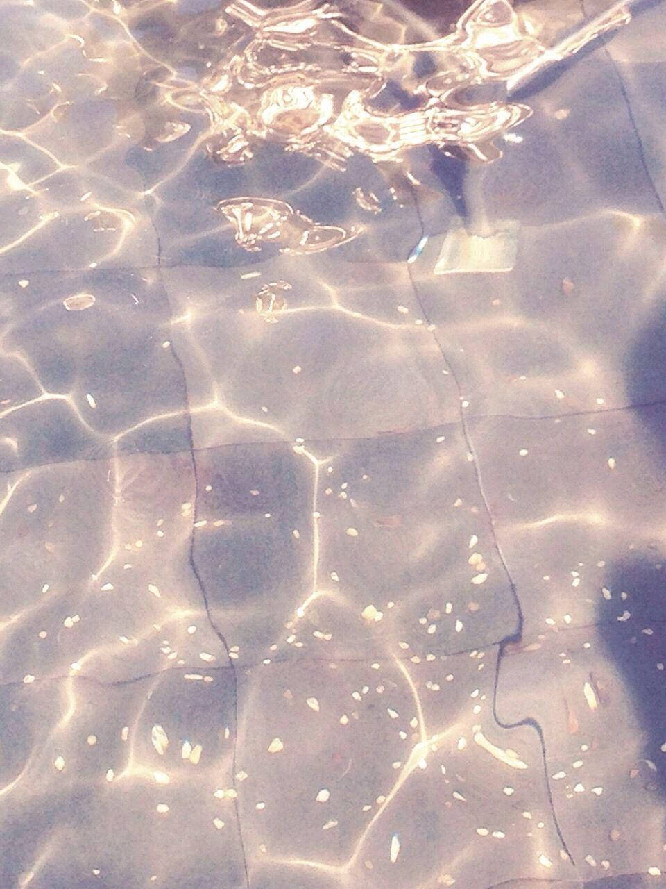 Water Aesthetic 桌布 壁紙 — 陽光在清澈的水面上泛起漣漪，露出瓷磚泳池地板在溫柔的波浪下。