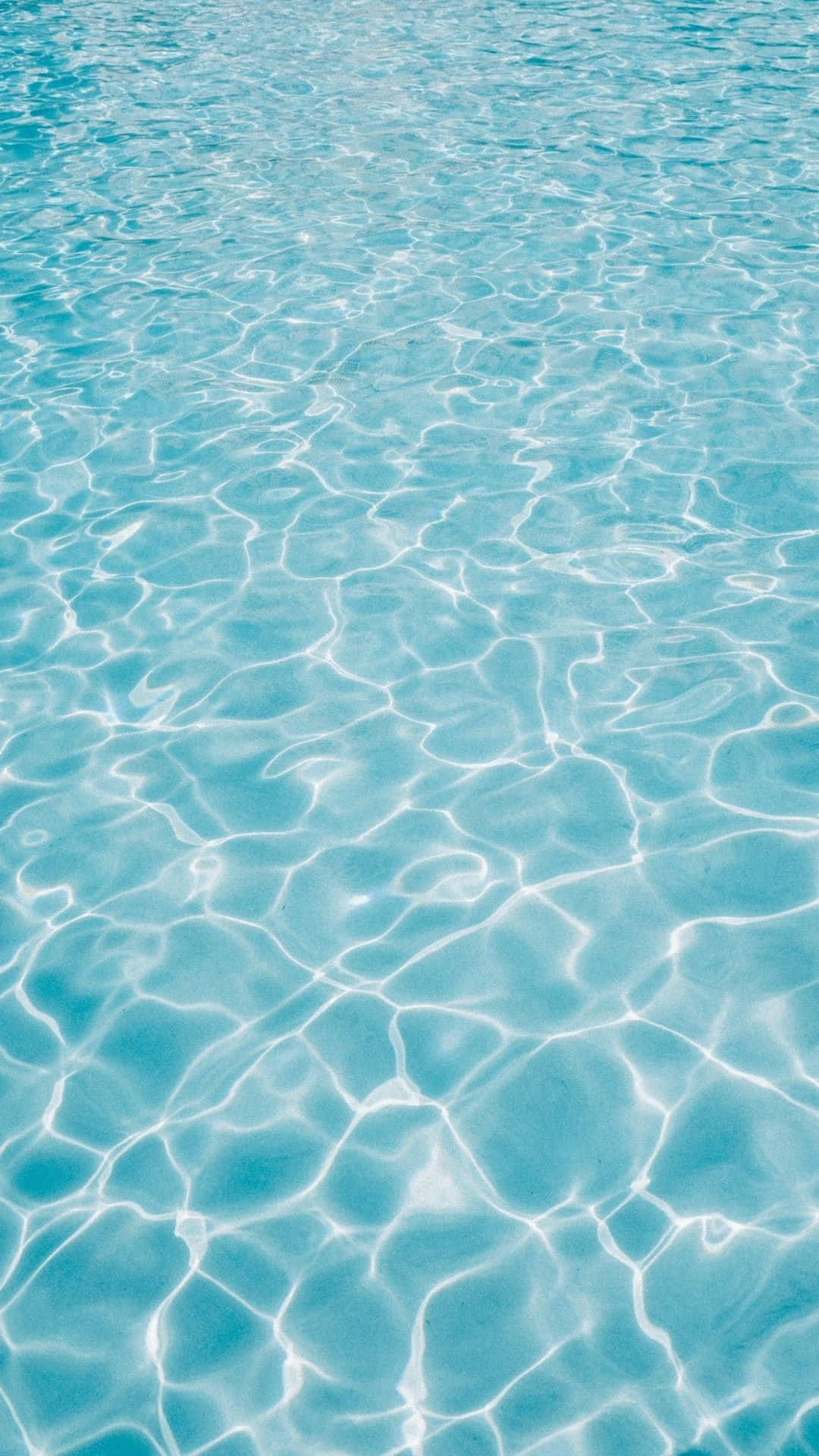 水 桌布 壁紙 — 陽光在清澈的碧綠水面上舞動，形成閃爍的漣漪和光線圖案。