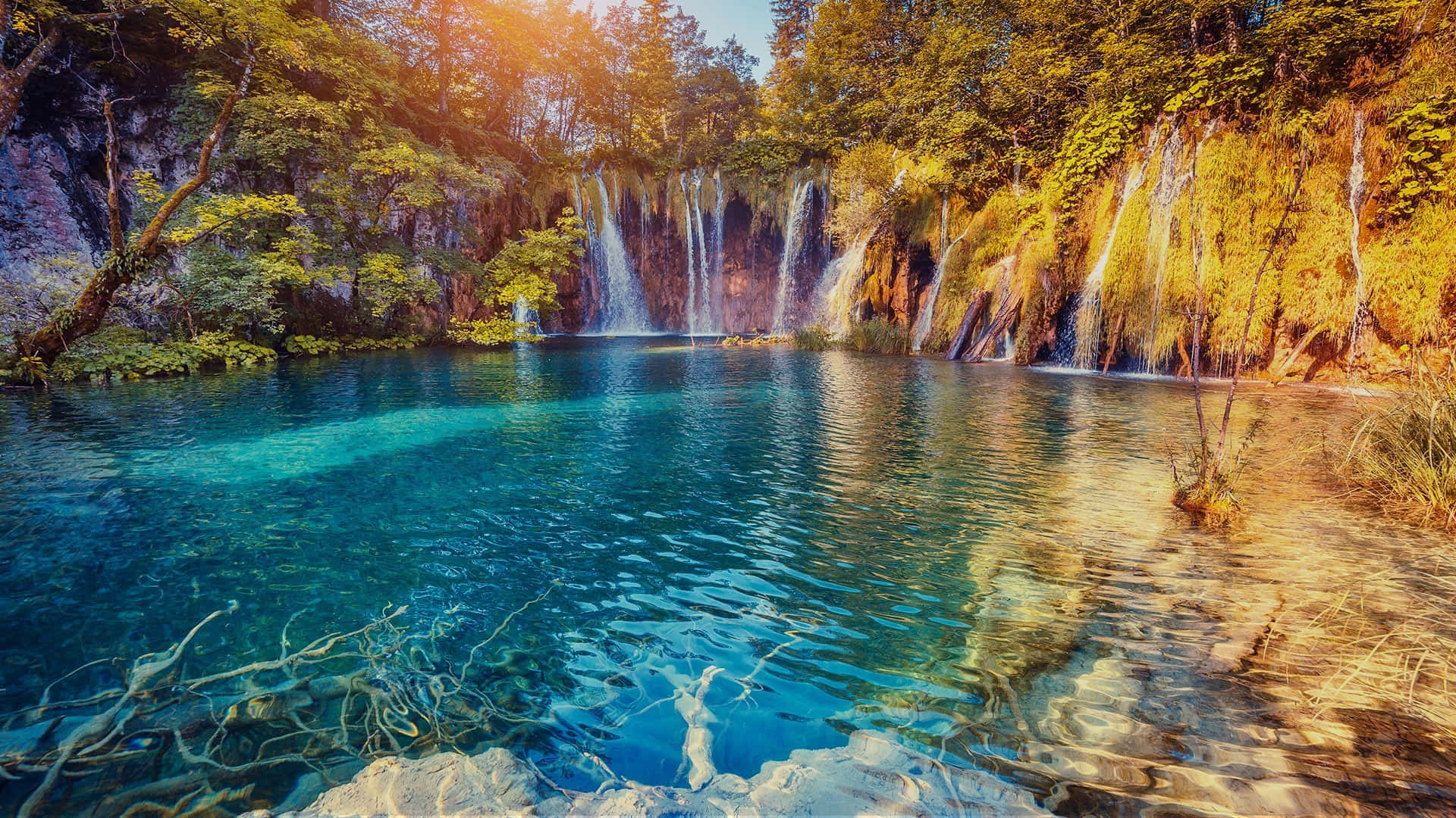 Lake 桌布 壁紙 — 陽光在碧綠的水面上閃爍，層疊的瀑布傾瀉入寧靜的森林水池。