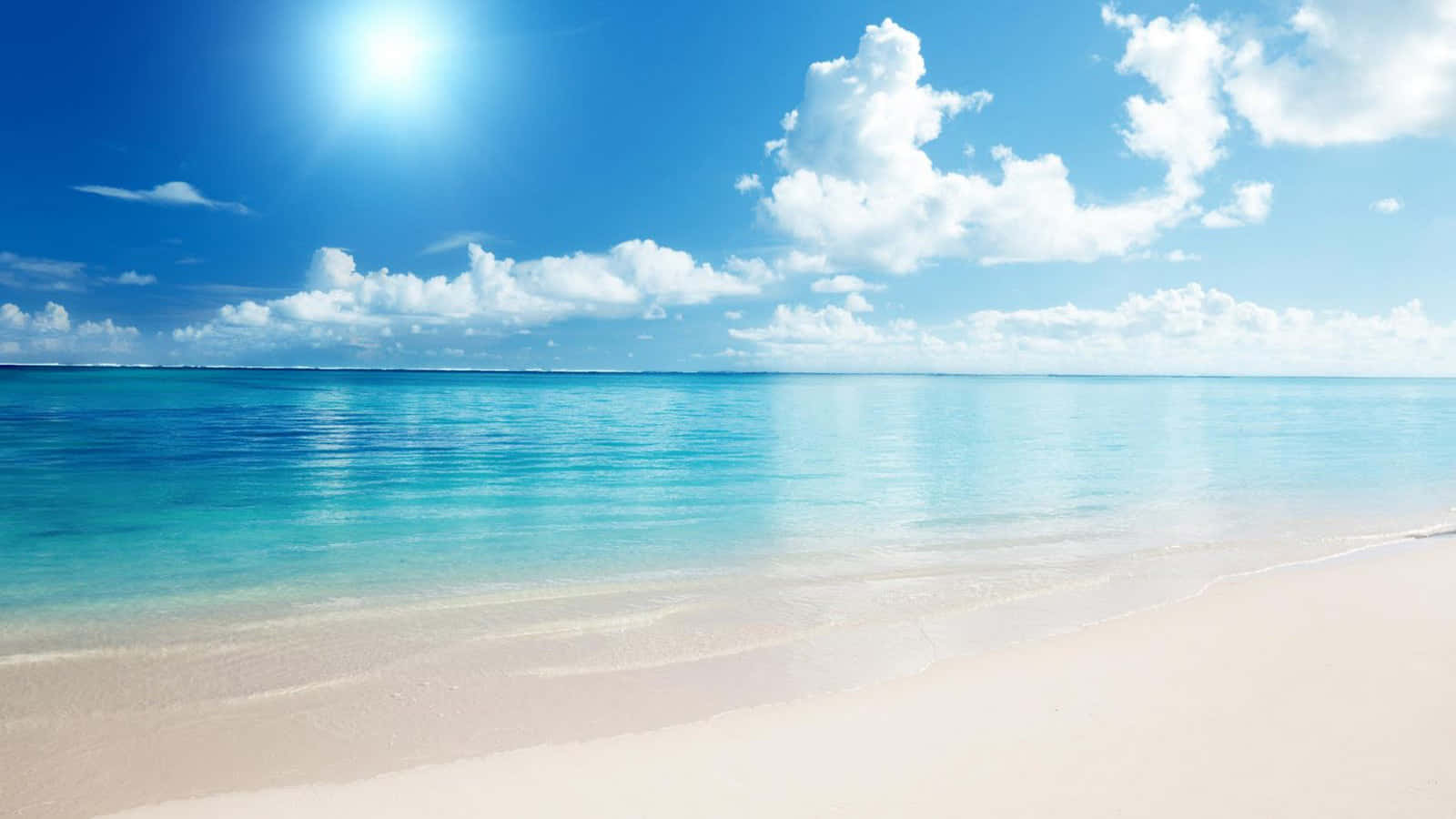 Beautiful Beach 桌布 壁紙 — 陽光在碧綠的海水上閃爍，與柔軟的白沙相遇，天空湛藍，白雲朵朵。