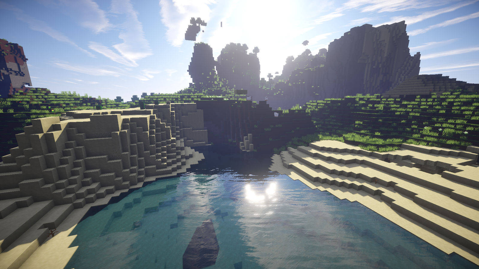 我的世界 高畫質壁紙 桌布 壁紙 — 陽光明媚的 Minecraft 峽谷，有塊狀懸崖、綠植和一個平靜的藍色水池，倒映著明亮的天空。