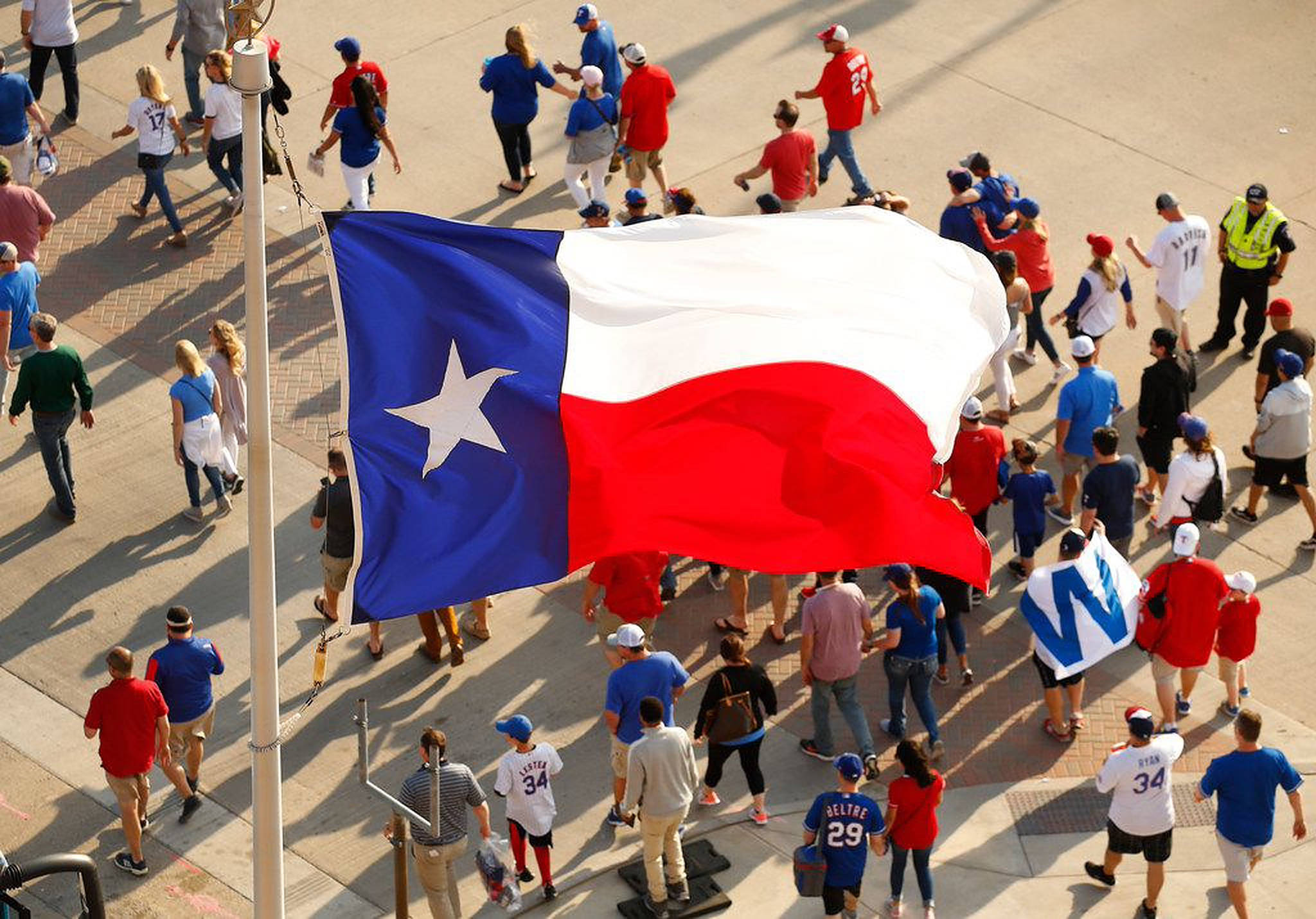 Texas Flag 桌布 壁紙 — 陽光明媚的日子裡，人群聚集在一面飄揚的大型德州旗周圍的鳥瞰圖。
