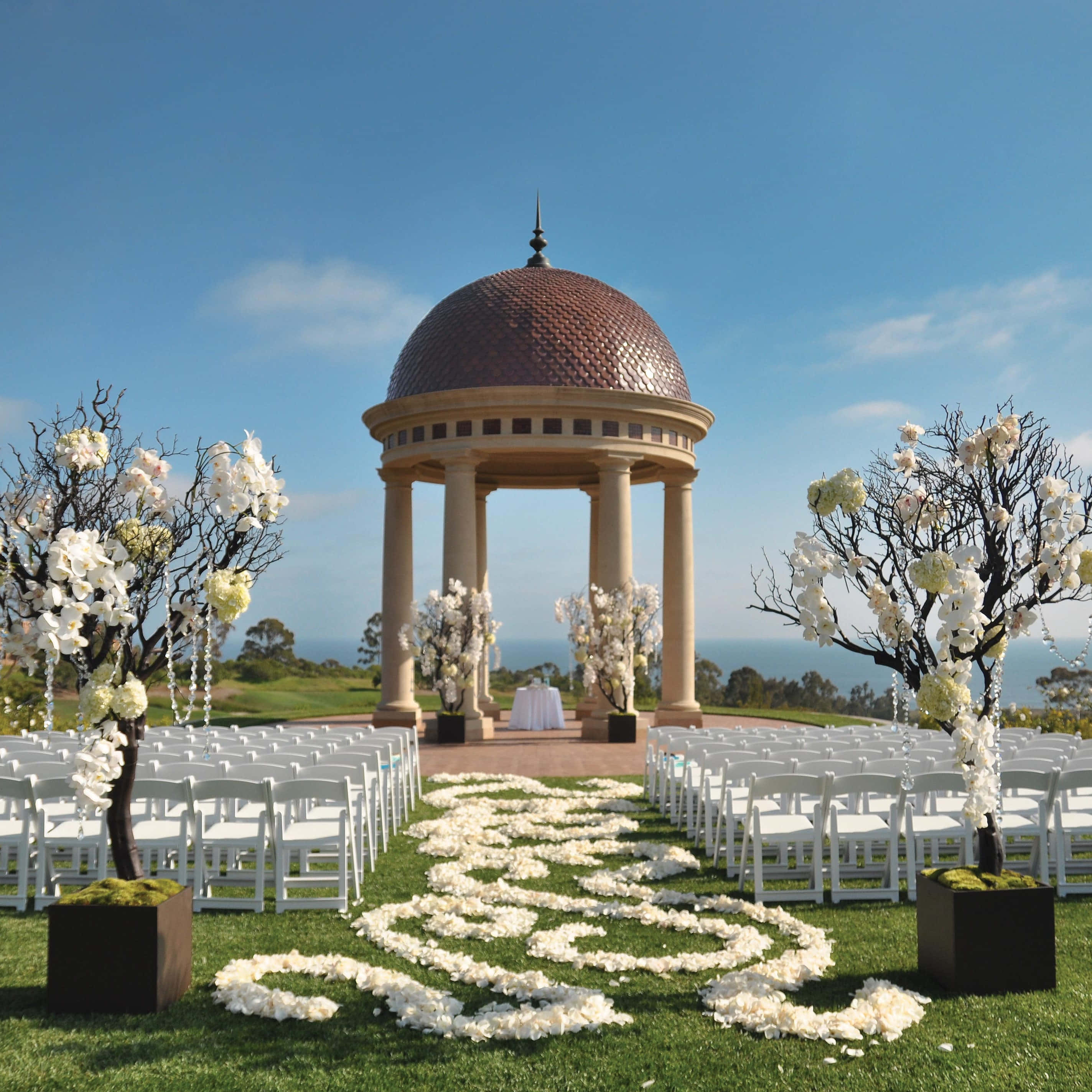 Garden Wedding 桌布 壁紙 — 陽光明媚的日子裡，在圓頂涼亭下舉行盛大戶外婚禮，配有白色椅子和花卉佈置。
