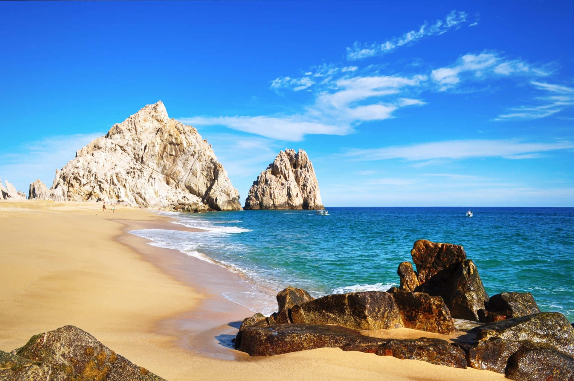 Mexican Beach 桌布 壁紙 — 陽光明媚的海灘，金色沙灘、碧綠海水和巨大岩石群，在清澈的藍天下。